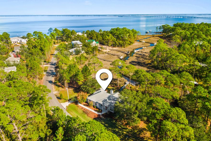 This waterfront estate is a rare opportunity, spanning two lots navigable to the bay with panoramic views of Choctawhatchee Bay. The property is on 325 feet of paved road frontage and offers 230 feet of navigable waterfront on 'Gurkee Creek,' with direct access from your private boat dock through the federally protected estuary to the bay. The custom-designed home has been meticulously maintained and thoughtfully updated, offering three bedrooms and two baths with flowing, spacious living areas highlighted by scenic vistas throughout, a covered, screened back porch, surrounded by a quiet park-like setting with mature oaks, magnolias, azaleas, and camellias. Additional features include a 40-year steel roof, oversized garage and driveway, and second driveway suitable for camper and second driveway suitable for camper or boat parking.
Conveniently located near Gulf beaches, Scenic Highway 30A, shopping, dining, entertainment, marinas, and healthcare including Ascension Sacred Heart, offering an exceptional balance of waterfront privacy and everyday accessibility.