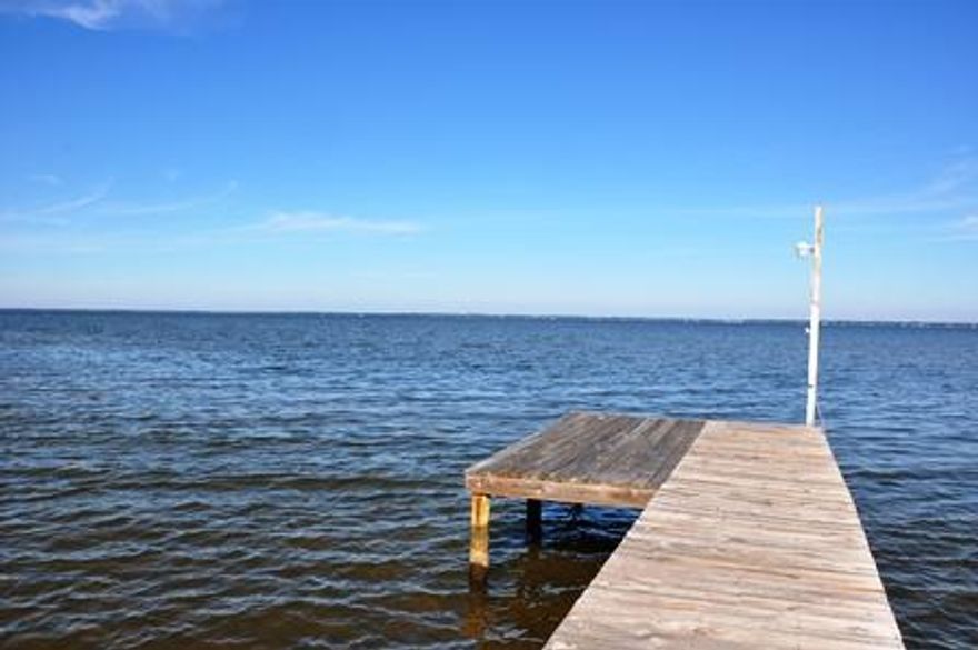 This beautiful one level home nestled among stately live oaks features 100 feet of Choctawhatchee Bay frontage. Anchor your boat on the 95 ft. dock and take a dip in your private backyard pool. Spectacular panoramic views from the living room, den, master bedroom, and kitchen. Vaulted ceilings in living room with wood burning fireplace. Oversized garage with workshop area.This very well maintained home is move in ready. Update kitchen counters and baths or play in the bay and enjoy it as is.