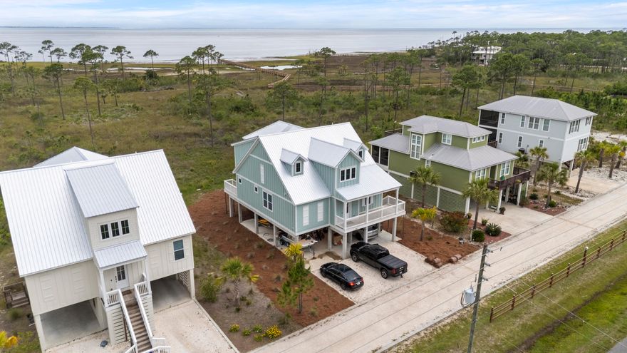 Experience coastal living at its finest with this stunning two-level ''Ocean'' floor plan overlooking the breathtaking St. Joseph's Bay. The spacious primary bedroom boasts serene water views, a luxurious en suite bathroom featuring a large soaking tub, separate frameless walk-in shower, dual quartz-topped sinks, and a private water closet. Step directly onto the front screened-in porch from the primary suite to enjoy Relaxing Gulf Coast Sunsets. The second bedroom offers convenient access to a full bathroom, while an adjacent laundry room showcases tile floors and custom shelving. Throughout the home, elegant crown molding and ceiling fans complement sleek wood look tile flooring. 10-foot ceilings on the main level and 9-foot ceilings upstairs contribute to the feel of elegance mixed with coastal charm. The gourmet kitchen is a chef's dream, outfitted with quartz countertops, 42-inch luxury cabinetry, a vented microwave, stainless steel appliance package, pantry, and a large stainless farmer's sink. Ascend to the expansive loft, which opens to a generous second-floor balcony with captivating water views, ceiling fan, and wood-covered ceilingsperfect for relaxing or entertaining. The third and fourth bedrooms each feature private full bathrooms and stunning water vistas. Enjoy morning coffee or evening breezes on the front porch, Every door and window is constructed with high-impact materials for safety and durability. With a public Gulf Access Point and the vibrant Downtown Port St. Joe just minutes away, this home offers the ultimate blend of tranquility and convenience. Don't miss your chance to live the waterfront lifestyle you've always dreamed of!
