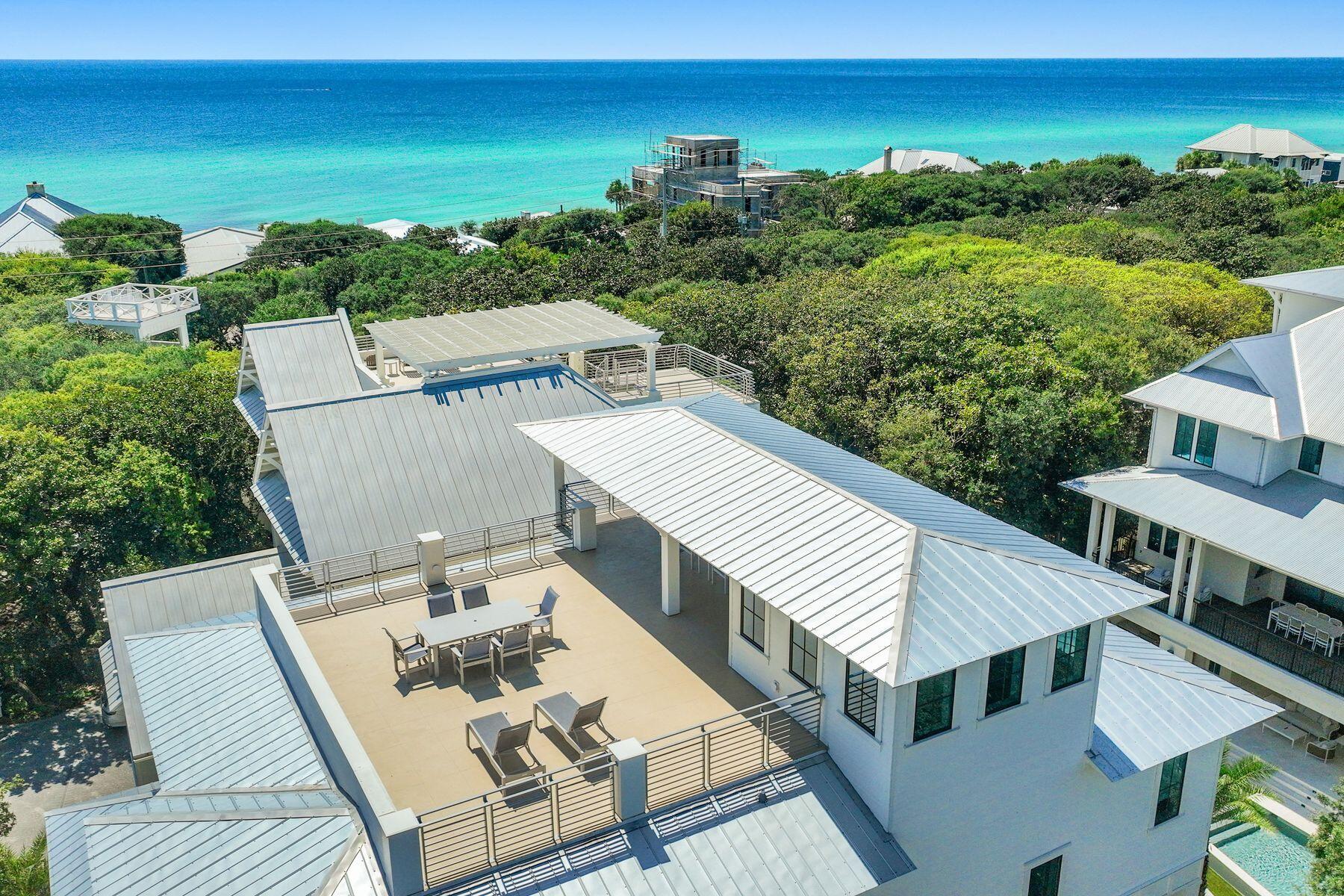Welcome to 57 Azalea Street, a beautiful beach retreat located in Old Seagrove. This home offers luxury coastal living with two public beach accesses just 250 steps away. The home features 8 bedrooms and 8.5 bathrooms, plus a private resort-style pool, outdoor kitchen, dining area, bar space, rooftop deck with Gulf views, game room, and an elevator. The first level features a family entertainment area with a large game room. It also includes a guest bedroom with an ensuite bathroom and a bunk room with three Queen-over-Queen bunks and a shared shower. On the second level, the open living area combines elegance and comfort. The gourmet kitchen has high-end stainless steel appliances, a large marble-topped island, and custom cabinets. Step outside to the spacious terrace and take in the views of the resort-style pool and hot tub, which look beautiful at any time of day. In the primary suite, a king-sized bed welcomes you to relax. The ensuite bathroom feels like a spa, featuring a deep soaking tub, a large walk-in shower, and double vanities. There are also Twin-over-Twin bunk beds for extra guests. The third level focuses on guest comfort and privacy. It includes an additional primary suite with a private bathroom that has a shower and soaking tub, three guest suites with private bathrooms, and a two-twin bedroom with a private bathroom. End your day by enjoying a cocktail on your private rooftop deck as you watch the stunning sunset paint the sky with gold and pink colors. This luxury beach home represents elegance, comfort, and modern style. Experience the best of coastal living, where every detail is carefully designed.