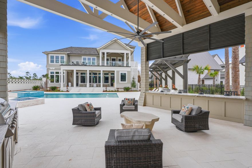 460 Golfridge Drive presents an architecturally striking coastal residence in Inlet Beach, offering more than 6,700 fully furnished square feet of conditioned living space defined by refined craftsmanship, curated materials, and thoughtfully designed indoor-outdoor living.Inside, the home's scale and natural light create an immediate sense of openness. Twelve-foot ceilings run throughout, with select spaces rising to vaulted heights of 15 to 18 feet, enhancing the airy, gallery-like atmosphere. Seven-inch engineered white oak flooring carries throughout the residence, complemented by carefully selected finishes and high-end pendant and chandelier lighting, including a remarkable Italian-made all-glass Chanel chandelier that serves as a sculptural centerpiece. The primary kitchen pairs elegant design with exceptional functionality. Custom white oak cabinetry, dual 48-inch gas ranges, and a dedicated wine chiller and serving station anchor the space, while a nearby wine room with built-in racks set against an oak feature wall creates a distinctive setting for entertaining and collection display. The adjoining living area is centered around a gas fireplace, offering warmth and architectural balance to the open gathering space.

Bathrooms throughout the home reflect the same level of thoughtful design, featuring fully tiled showers and custom-crafted vanities, alongside curated John Richard furnishings and finishes that bring a tailored, design-forward aesthetic to the interiors.

Outdoor living unfolds across beautifully composed spaces designed for both relaxation and entertaining. A large sun terrace overlooks the pool, pavilion, and tranquil lake views, framed by tempered impact glass railings that maintain unobstructed sightlines. Below, the backyard becomes a private retreat with white limestone pavers, a heated pool and hot tub with sun shelf, and a custom-built gas fire pit creating a welcoming focal point for evenings outdoors.

The pool house pavilion extends the home's entertaining capabilities with a thoughtfully equipped outdoor living area featuring a 70-inch television, electric fireplace, bar refrigerator, Blaze stainless gas grill, and outdoor sink, along with a full bathroom and storage. Extensive brass Volt landscape lighting highlights the home's architecture and surrounding grounds, while a whole-home Bose sound system provides seamless audio both indoors and throughout the outdoor living spaces.

Additional architectural and design details include Decra stone-coated aluminum shake roofing, natural gas copper lanterns, a laundry chute from the second floor, and a heated and cooled three-car garage that adds flexibility and convenience.

With its generous scale, carefully curated finishes, and beautifully integrated outdoor spaces, 460 Golfridge Drive offers a sophisticated interpretation of coastal living--where architectural integrity, comfort, and elevated design come together in a setting designed to be experienced and enjoyed.
