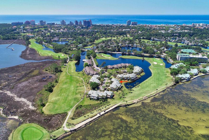 Stunning bay and golf course views are offered from this lake front Grand Harbour unit on the exclusive Sandestin Golf and Beach Resort! The main level offers a large and open living room which flows into the dining area and kitchen. A screened-in lanai affords great views of the lake, golf course, and bay. The laundry room and a guest room are also located on the main level. The second level offers a spacious master suite with large walk-in closet, and private patio with open and unobstructed views that will take your breath away. A second guest room with guest bath is located upstairs as well. Grand Harbour is perfectly situated in the center of Sandestin, not far from the main gate. The roof was just replaced last year. It includes a community pool that is shared with Harbour Point.