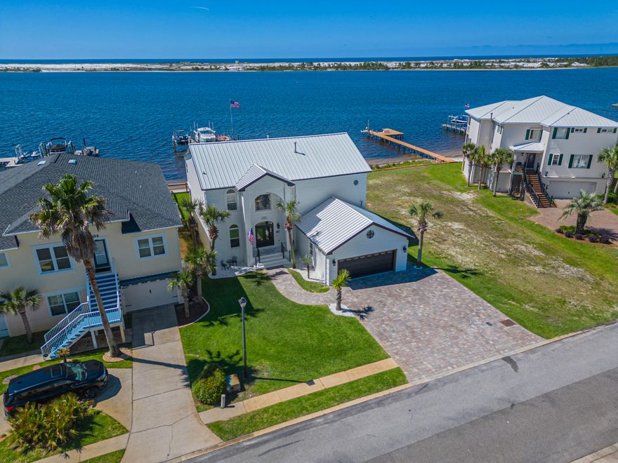 $75K PRICE IMPROVEMENT! Listed BELOW Recent Appraisal!! Motivated Seller! Wake up in a coastal dream home that offers the ultimate in waterfront living. This beautifully renovated estate, located on the picturesque Santa Rosa Sound, boasts uninterrupted views of Santa Rosa Island and the Gulf of Mexico. Enjoy your own private white sandy beach, a boardwalk, and a $150K low profile dock facility equipped with four boatlifts, 50amp power, a fishing and relaxing platform, and deep water access (6-7ft!).

Inside, the home features a stunning open layout with panoramic views and luxurious elements, such as a two-story atrium and a graceful, curved staircase. The main level includes a spacious office and a sophisticated living area adjacent to a chef's dream kitchen. This kitchen is outfitte with abundant cabinetry, elegant quartzite countertops, a Wolf stove with a French burner, double ovens, a central island, and a separate bar complete with a built-in kegerator. Additionally, the main floor hosts a versatile guest room or bonus room, a full bath, and a custom butler's pantry. The expansive living area and kitchen open onto a large screened-in porch, perfect for grilling with its natural gas hookup, and ample space to unwind and take in the breathtaking views.

Upstairs, three waterfront bedrooms lead to a fully finished, climate-controlled sunroom with spectacular vistas. The primary suite is a retreat unto itself, featuring an extensively renovated bathroom with a walk-in shower, illuminated mirrors, and an enormous custom closet with integrated shelving and a laundry area.

This move-in ready home is packed with exceptional features and upgrades. Don't miss your chance to own a slice of paradise!