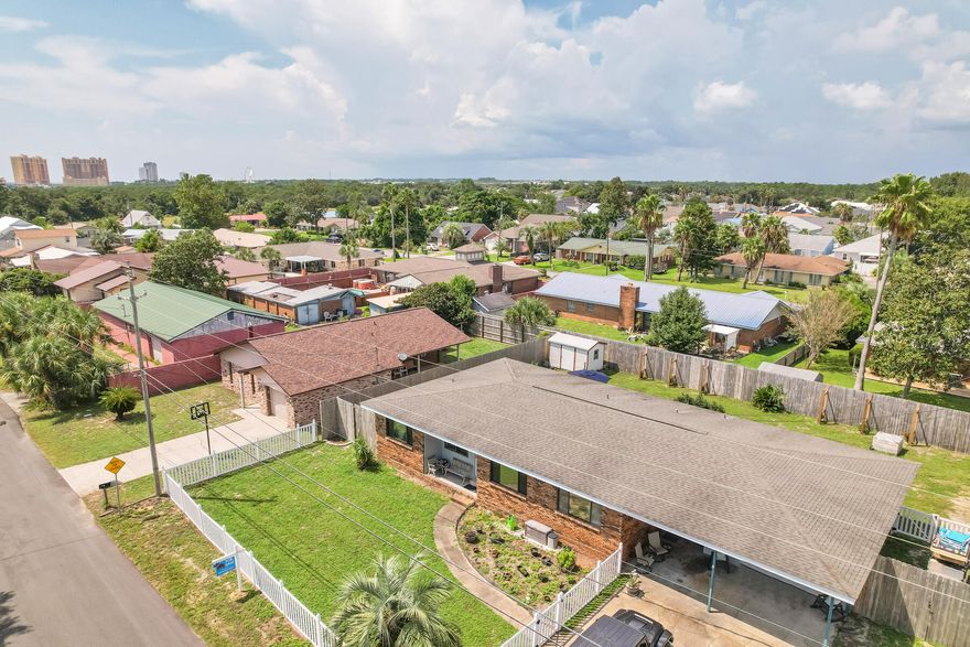 This home is located 2 blocks away from the beach. This neighborhood is across the street from the Harley Davidson store and Pier Park is 2 miles away. There are many restaurants and stores in the area. The property is nearly a quarter acre and sits on a double lot.  This home has an open floor plan with tiled floors throughout the home. The garage has a workshop and covered parking. The property is completely fenced in and has a large backyard with a shed. Call me to get your slice of paradise.