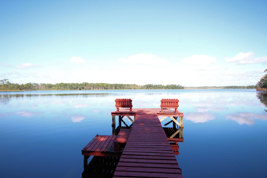 Your own private oasis that says welcome with a beautiful natural Florida setting! This home is a Rare Jewel situated on over 2 acres of land that offers 175 feet on Basin Bayou overlooking the serene bayou as you watch osprey soar, fish jumping and otters playing. Land that trophy bass, fishing in the spring fed stream that feeds the bayou. Spend your leisure time on your own dock that offers tranquility and privacy. The sellers enjoy magnificent views of the Bayou all year round with its 2 high and dry acres that also offer ancient, moss draped oaks, azaleas, gardenias, dogwood, crepe myrtles and many other varieties of plants providing year round beauty. Situated on this land is 2 vintage Florida cottages; the main home built in 1953 and your guest home built in 1943. The 1953 home interior features approximately 1200 sq. ft with 2 bedrooms, 2 bathrooms, living area with fireplace, kitchen, dining room, utility room and a four season sun room. It has central heat/cooling.   The home is accented with tongue and groove walls and wood floors.  The guest cottage built in 1943 is situated near the bayou banks with approximately 600 square feet with one bedroom, one bathroom, sleeping porch, eat-in kitchen, screened back porch and home is equipped with emergency generator.  Home features wood floors.  The property also has 2 workshops to complete all of those honey-do lists and a small pole barn. There is both well and city water to the property. A lawn pump provides a sprinkler system for much of the property. This property has been immaculately maintained. Come and enjoy the bayou breezes from your dock for a leisure day, reading your favorite novel and a cup of cappuccino.  Your lot is perfect for those July 4th parties or gatherings, water skiing, fishing, crabbing, floundering, bird watching or wherever your imagination takes you, this is truly a piece of paradise.  Imagine the opportunities are endless, you could become a landlord and rent one of the homes, you could rent both and build your dream home, and you could perhaps use this property as a fishing camp with easy access to state property possibly for hunting.  Consider the life altering possibilities as you live the great southern lifestyle in this waterfront home.  The property is being sold ''As Is'' due to the age of the cottages.