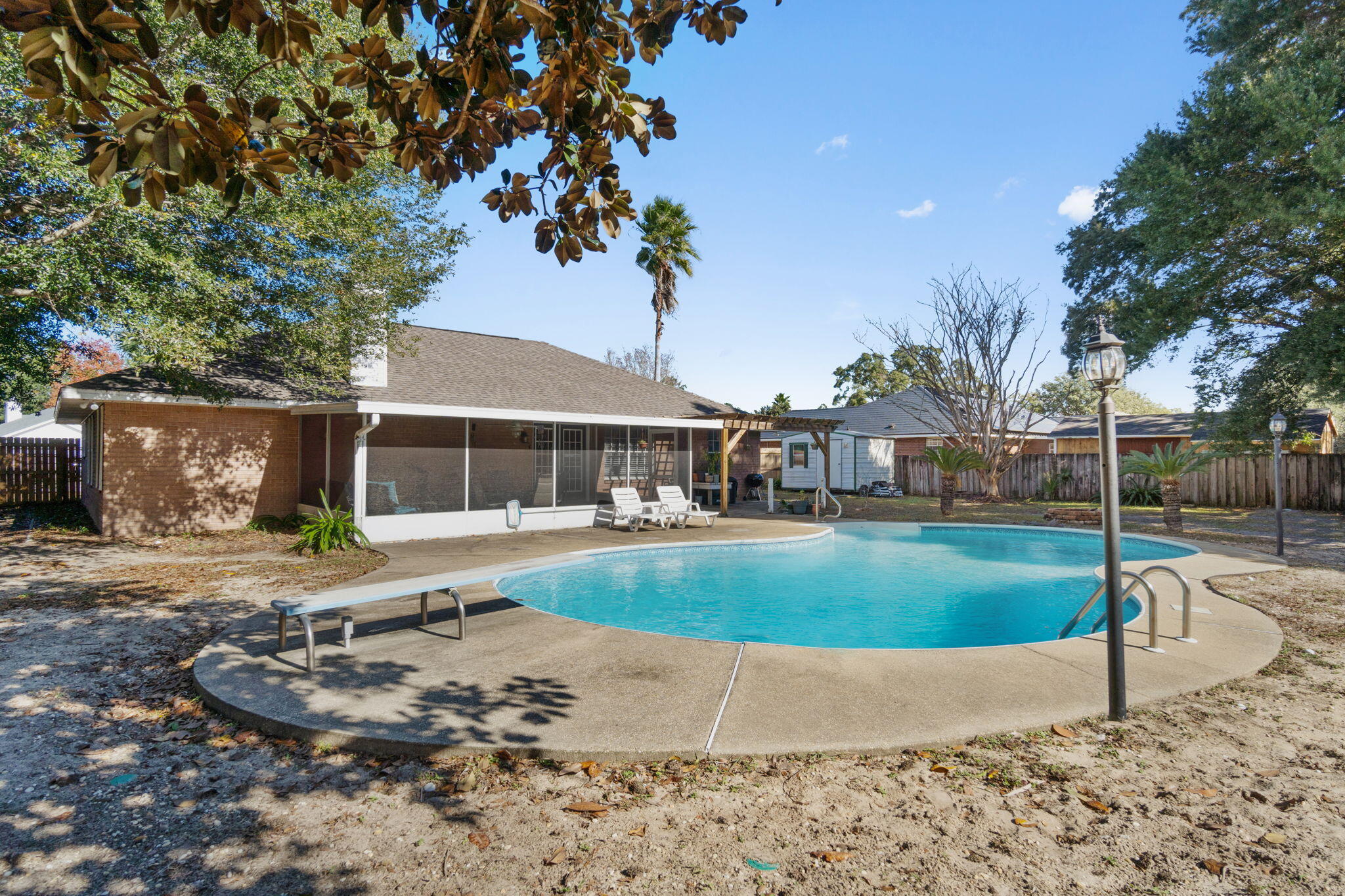 *Pool Home!* Situated on a spacious corner lot in Navarre's Spanish Trace Estates neighborhood you're going to love this pool home featuring 3 bedrooms, 2 bathrooms, and 2 additional separate flex rooms (often used as a formal dining room and office/den). Enter in the front door past the tropical landscaping and you'll find the two flex rooms on either side with a great sized living room just past that featuring a corner fireplace and vaulted ceiling. The kitchen has a hop up bar and is open to eat in kitchen space which overlooks the backyard. There is NO carpet in this home, only hard surface flooring! The split floor plan allows for owner's suite privacy with a great sized room and an en suite which has TWO walk in closets, double vanities, a walk in linen closet, private water closet, and a walk in tiled shower. The other two bedrooms are great sized and share a fully renovated guest bathroom! The interior laundry room leads to the 2 car side entry garage. Enjoy the outdoors or entertain with the large screened enclosed patio, a pergola offering additional seating area and a very spacious back yard with beautiful oak trees and featuring a large in ground swimming pool within the fully fenced in back yard complete with an outdoor storage building! Experience the best of Florida living close to Navarre's beautiful Emerald Coast beaches! Roof is 2022 and water heater is 2018.