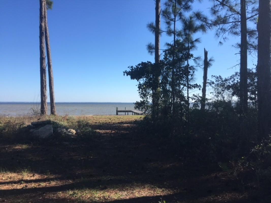 Beautiful premium wooded lot with approximately 93 feet on Choctawatchee Bay in Destin. Sturdy seawall with dock. Exquisite view of the bay. Walton County is paving Paradise Point Lane in 2017. Large lot, approximately 0.6 acre (refer to survey for exact dimensions).