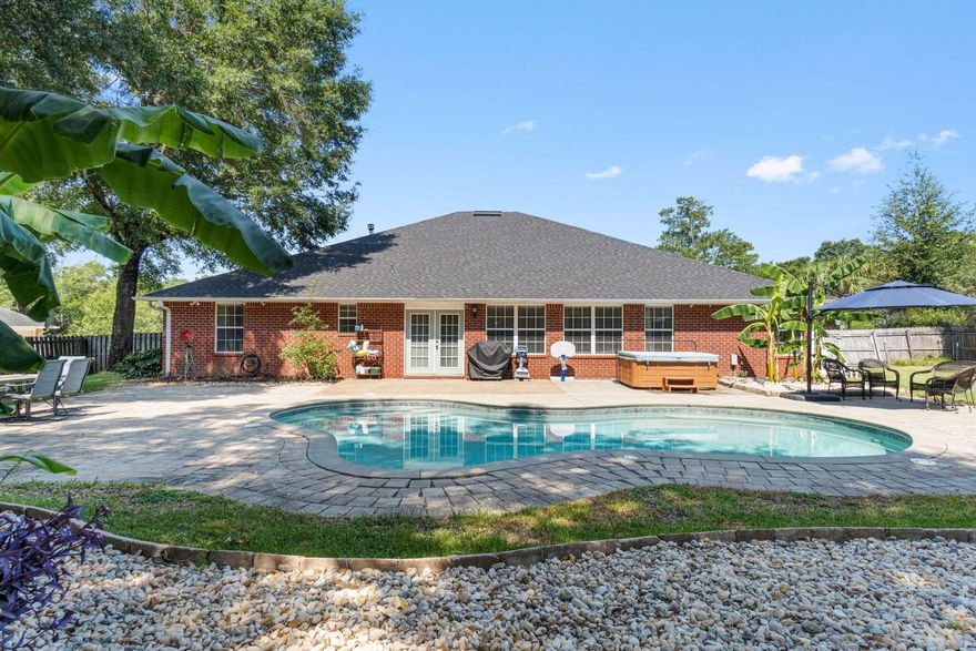 Welcome home to this stunning four bedroom (plus an office, formal dining room and bonus room!), three bathroom home in the desirable Gardenbrook subdivision with a salt water gunite heated pool on an expansive 0.71 acre lot! With a hot tub, 2022 roof, 2022 water heater, a fully fenced in and irrigated massive backyard, and workshop/shed with electricity you're not going to want to miss this one. Pull into the long and oversized driveway and walk up to the front door where you'll find a fantastic covered front porch. Step into the foyer and you'll immediately love the cherry hardwood floors that continue into the main areas of the home. Just to the right of the foyer is the office and to the left is the formal dining room with a doorway leading into the kitchen. The living room is enhanced with open decorative ledges and a gas fireplace. The stunning kitchen features Kenmore Elite stainless-steel appliances, granite countertops, solid wood cabinets, a functional island with electricity, and a pantry. This is no cookie cutter home, you're going to love the antique brick flooring that extends throughout the kitchen, interior laundry room which leads to the 2 car side entry garage, and bonus room! The split floor plan of the home allows for privacy, with two great sized bedrooms and a full bathroom off the living room, and an "in-law suite" off a hallway behind the living room. The massive 13'3"x17'1" in-law suite also has an access door to the bonus room from the full sized bathroom. The bonus room overlooks the gorgeous backyard and is accessible from the in-law suite, the living room and the eat-in kitchen and features two sets of french doors with those gorgeous brick floors. The owner's suite is nestled off the kitchen and is a great oasis complete with a trey ceiling and cherry wood flooring. The owner's en suite features two walk-in closets, a garden tub, double vanity and a tiled walk-in shower. The backyard truly has the WOW factor and is made for entertaining! The gunite saltwater pool deck is finished with pavers and the pavers continue to the fire pit and an extended patio area for seating and is complete with a hot tub as well! The private backyard is large with a children's play set and a workshop and the fully fenced in yard features a double gate. The home has an active termite bond and routine pest control service, the pool pump was replaced in 2023, there is a child safety pool fence located in the outdoor storage building, and the house has a pad and was wired to be able to add a whole home generator! Welcome home!
