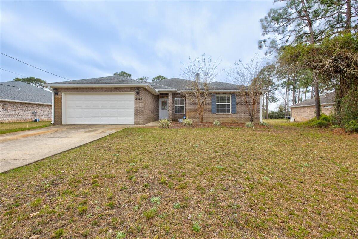 Lovely, all-brick, 4-bedroom home with 2-car garage, on half an acre, with a short commute to bases, beaches, schools, parks (backs up to Navarre sports complex), shopping, and more! The spacious living room features a fireplace and double doors leading out to a covered back porch overlooking the back yard, and the kitchen has stainless appliances, including a flat cooktop stove. There is a split floor plan, for privacy, and the master has tray ceilings, a walk-in shower, jetted tub, double vanity, separate toilet room, and walk-in closet. The three guest rooms share a full guest bath, and this home has a brand new water heater. Seller to replace roof before closing with list price or better contract.