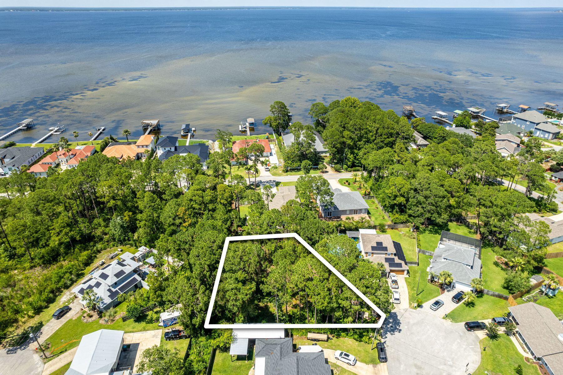 Discover the perfect homesite in Holiday Shores, an exquisite lot offering the potential for stunning bay views. Nestled near the serene shores of Choctawhatchee Bay, this property is ideal for full-time residents or second homeowners seeking a peaceful retreat with convenient access to everything Sandestin and Destin have to offer. Located on a quiet cul-de-sac, this spacious lot provides an inviting environment for families while just a short distance from premier shopping, golf courses and renowned restaurants. Enjoy the ultimate coastal lifestyle by taking a quick golf cart ride to the beach or the Seascape Town Centre. Positioned in a high and dry X flood zone, this lot requires no flood insurance and comes with no HOA fees, ensuring a hassle-free ownership experience. A survey is