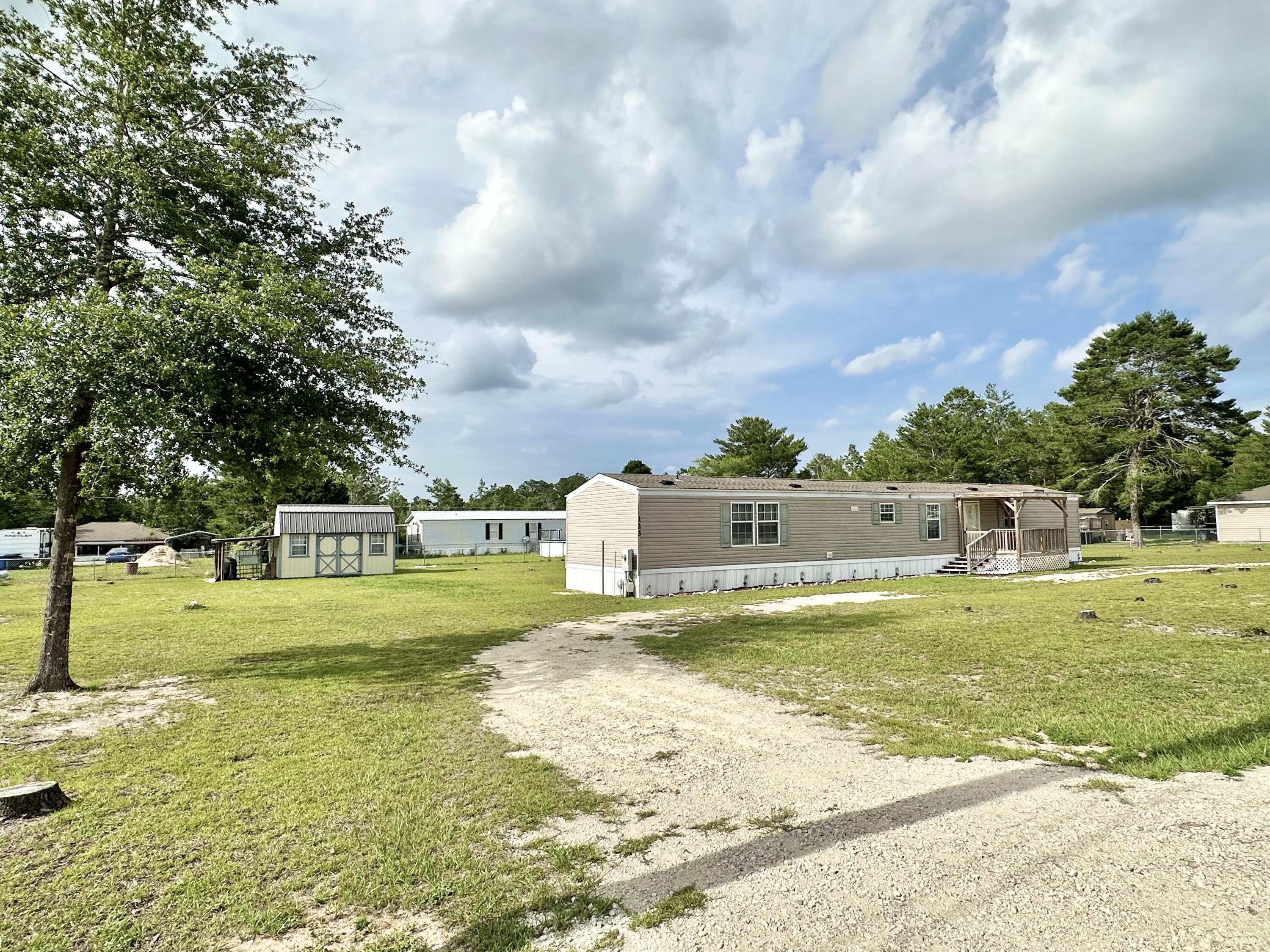 Discover comfort and convenience with this well-kept manufactured home nestled on a generous triple lot totaling 0.68 acres. Whether you're a first-time buyer or an investor on the hunt for a smart addition to your portfolio, this property delivers value and versatility.. Centrally located between DeFuniak Springs and Crestview. This 3-bedroom, 2-bath home features a concealed laundry area off the kitchen, a newer roof, updated HVAC and hot water heater. Enjoy both front and back covered porches, a chain-link fenced yard, and a detached storage shed with AC and electrica"ideal for a workshop or additional storage. Plenty of outdoor space for pets, gardening, or future additions. Reach out for a private showing today!