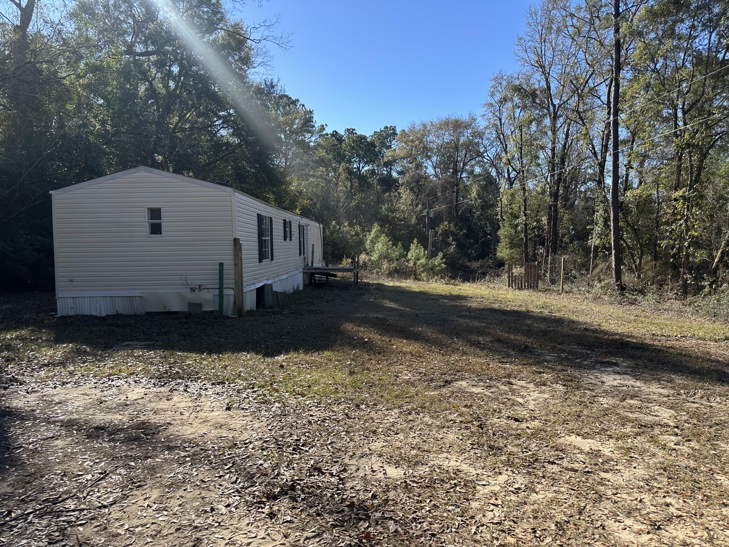 A cleared acre in North Crestview, beautifully surrounded by trees-an ideal spot for a new home or potential rehab of the existing 2010 mobile home. The property is being sold in AS-IS condition , and buyers are encouraged to verify all measurements. Schedule your tour today !