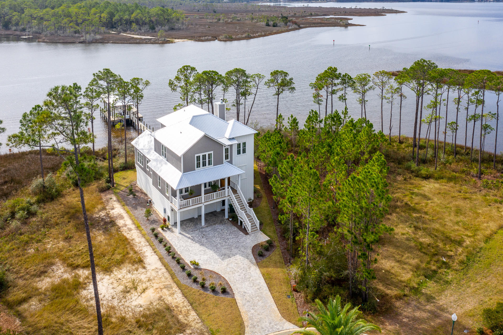 Astonishing south-westerly sunset views characterize this one-of-a-kind waterfront retreat. Situated on beautiful Hogtown Bayou, this custom designed home creates the perfect haven for the unspoiled lifestyle. Featuring 119 feet of waterfront footage, this property boasts a large open concept great room emphasized by a spacious chef's kitchen, vaulted ceilings, reclaimed solid wood beams, and distinctive venetian plastered gas wood-burning fireplace. Offering 5 bedrooms, 3 full bathrooms and 1 half bathroom; 55 Teal Court is the ideal home for entertaining family and guests. The chef's kitchen features a Thermador gas range, Thermador 36' built-in refrigeration, farm-house sink, quartzite natural stone countertops and a walk-in pantry with microwave and beverage fridge.