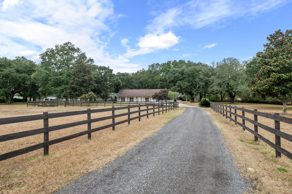 Your dream home awaits in Chavers Farms, where rustic charm meets modern convenience. Nestled on a sprawling 4.81-acre lot beneath stately old oak trees, this idyllic homesite offers not just a residence but a lifestyle. Complete with a working 2-stall barn, two fenced pastures, and endless opportunities, this property embodies the best of country living--all just minutes from modern amenities.This beautifully updated home provides peace of mind with a roof replaced in 2018, updated kitchen appliances, quartz countertops, and a brand-new asphalt driveway installed just a few months ago. The home also features newly installed carpet in all bedrooms, adding fresh comfort and style. Custom features abound, including 42' counters, custom maple cabinets, vaulted ceilings, rounded corners, a central vacuum system, surround sound, and a pre-wired security system. The thoughtful split floor plan ensures privacy, with the master suite featuring a spa-like bath with a garden tub, fully tiled shower, and dual vanities. The screened porch, accessible from both the master suite and the great room, offers the perfect space to enjoy the serene views and cool breezes. The open-concept design allows the kitchen to overlook the breakfast nook and great room, complete with a cozy fireplace, making it ideal for gatherings.

Outdoor amenities are abundant. This equestrian-ready property features a 48x48 2-stall barn with a tack room, hay storage, built-in benches, and a pull-through for trailers or RVs. Additional features include a generator hook-up, RV 30 AMP outlet, well with a 5-horsepower pump and 315-gallon tank, and two septic tanksone for the home and one for the washing machine. A 12x36 slab provides extra storage space for a boat or RV.

This impeccably maintained property is completely move-in ready and offers the freedom of no HOA. Whether you envision additional animals or simply a peaceful retreat, the possibilities are endless. Located in the unrecorded, established community of Chavers Farms, this hidden gem is just three minutes from the new Hamilton Bridge connector, offering convenient access to shopping, restaurants, and I-10.