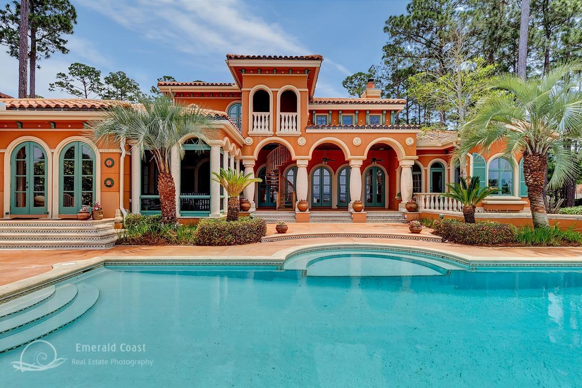 : Tuscan charm under the Destin sun! This spacious, bay front, 5 bedroom home sits on a deep lot with over 100 feet along the water in Sandestin's exclusive, privately gated, Burnt Pine neighborhood. It is a landmark home in Sandestin, noted for both its curb appeal when viewed from the street and its stunning rear symmetry when viewed from the bay. The large lot affords plenty of room for the generous brick motor court in the front and the huge, 40 foot pool in the rear. The home welcomes you through custom glass and mahogany doors, into an inviting living space with stone columns, arches, soaring ceilings, and a dramatic iron and stone staircase. Richly colored Mexican slate floors carry throughout the main living areas.