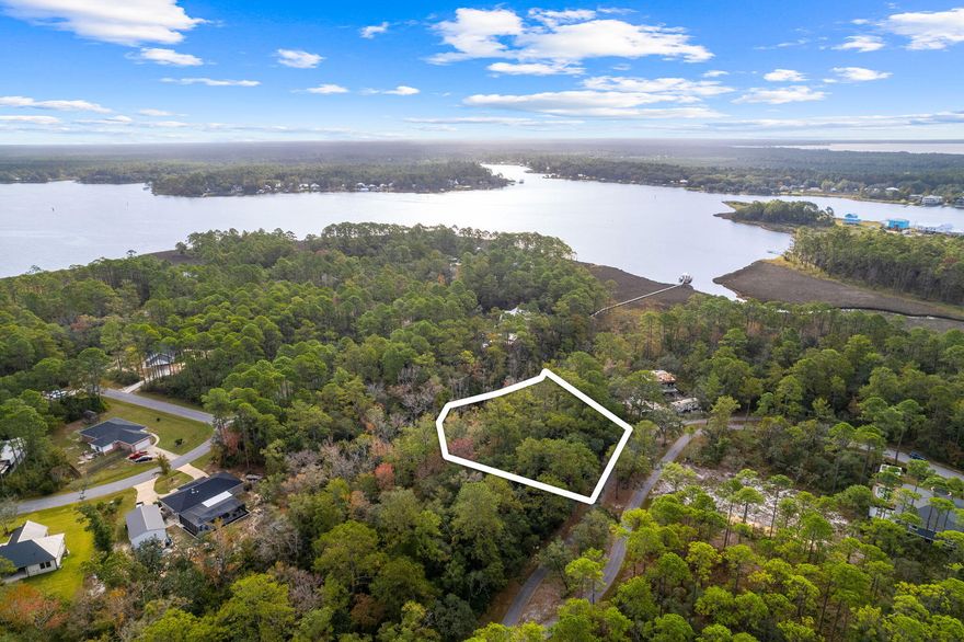 Spacious 0.44-acre lot, adorned with stunning mature hardwood trees. Potential water views with a two story build. Situated in proximity to the bay and scenic walking trails. Convenient access to Highway 20, making the beautiful beaches of South Walton a mere 20-minute drive away. Notably, there are currently no HOA dues. Protective covenants and restrictions are in effect to ensure responsible building practices.