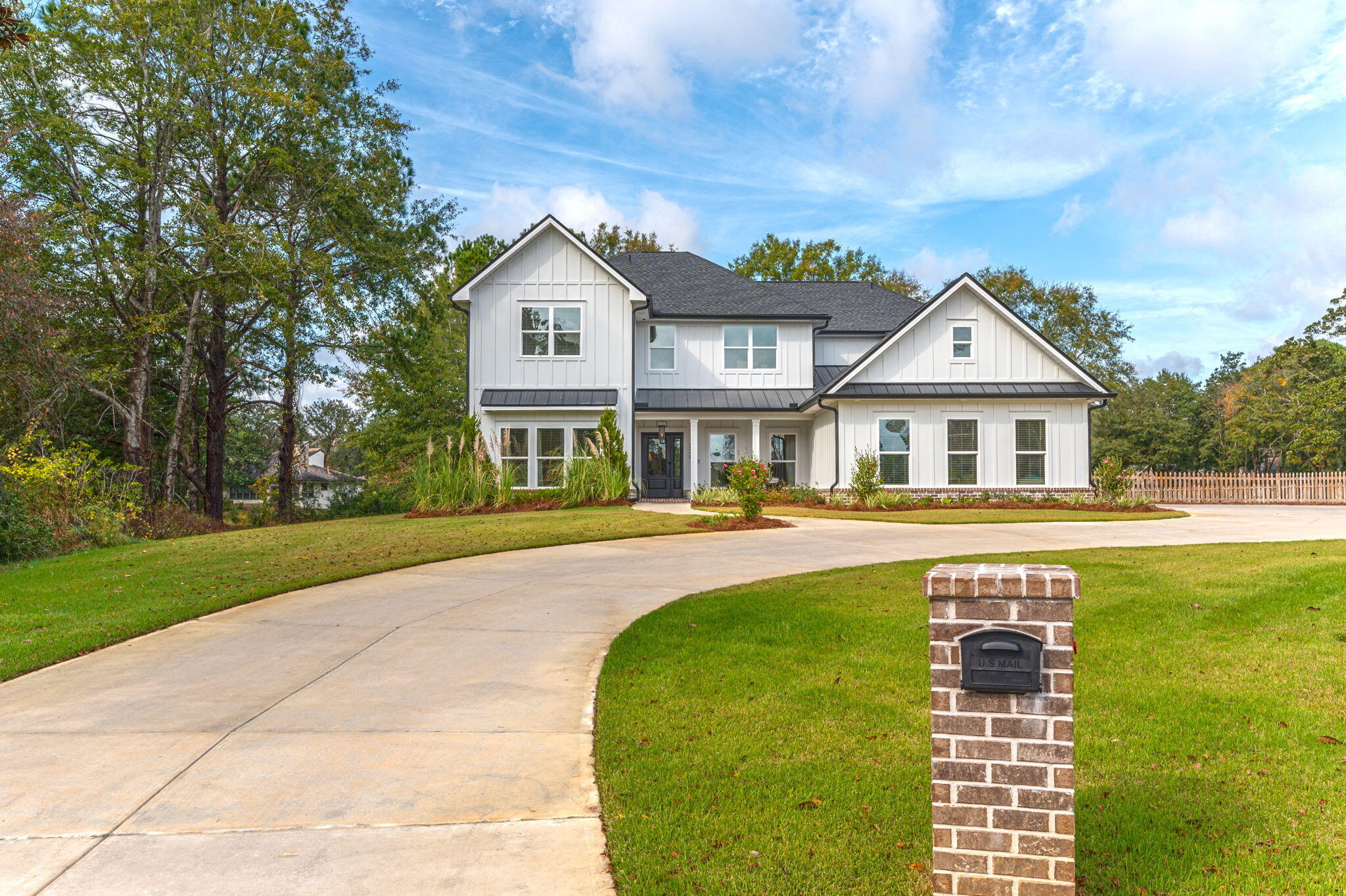 Available NOW - an extraordinary opportunity in Bluewater Bay's coveted Glenlake subdivision! Discover this 2022-built, 6-bedroom, 4-bathroom home tucked away on a rare, estate-sized 0.84 acre property boasting lake and golf course views. High contrast white siding and black roof combined with fresh landscaping create striking curb appeal and set the stage for the farmhouse luxe aesthetic found throughout the home. A gracious, Southern-style covered front porch and natural gas lantern offer a warm welcome to guests. Inside, find a truly spacious and infinitely flexible layout with 4282 square feet of heated and cooled living area. On the main floor, common spaces seamlessly connect thanks to an open concept layout that promotes both intimate and grand scale entertaining. The bespoke