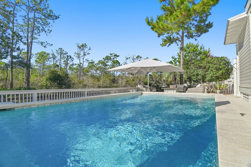 Positioned within the highly sought after NatureWalk at Seagrove community, this beautifully maintained two-story Florida cottage stands out as a truly exceptional coastal retreat. Designed for elevated outdoor living, the home's private backyard oasis showcases a temperature-controlled saltwater pool, commercial grade shade umbrellas, and a cozy fire pit, creating an idyllic setting for relaxation or entertaining in effortless style.  Projected to generate $133K annually, this residence offers a compelling opportunity for discerning buyers seeking a luxurious second home or a high performing vacation rental. Peacefully situated with serene pond views and backing directly onto the Point Washington State Forest, the property enjoys unrivaled privacy and immediate access to more 15,000 acres of preserved nature trails ideal for hiking, biking, and exploring. Spanning 2,539 square feet, the popular Sea Glass floor plan features rich wood flooring throughout and a welcoming fireplace in the main living area, fostering a warm yet sophisticated ambiance.   The professionally curated interiors embody the essence of the Emerald Coast, blending refined coastal details across four bedrooms, four bathrooms, and expansive open concept living spaces. Every room has been intentionally designed to balance everyday comfort with timeless elegance.  At the heart of the home, the chef's kitchen impresses with stainless steel appliances, including custom installed 33-inch professional refrigerator and freezer units, a gas cooktop, white shaker cabinetry, sleek granite countertops, and a grand 10-foot island perfect for hosting family and friends.  The primary suite offers a tranquil private escape complete with its own covered porch, ideal for a quiet morning coffee or peaceful evening unwind. Its spa inspired en-suite bath features a soaking tub, separate walk-in shower, and elevated finishes that evoke relaxation and rejuvenation. The garage provides ample space for vehicles, a golf cart, and all your beachside gear.

NatureWalk at Seagrove offers an exceptional lifestyle with premier amenities, including a community trail to the beach less than a mile away and The Gathering Place an amenity hub with a playground, heated lap pool, zero entry pool, hot tub, fire pit, grills, TV, and bar area.  Additional community highlights include fitness stations, multi-purpose courts, pickleball, and miles of scenic nature trails.  Whether envisioned as a personal coastal sanctuary or a standout vacation rental, this remarkable property delivers a rare blend of luxury, functionality, and investment potential within one of Seagrove's most coveted communities
