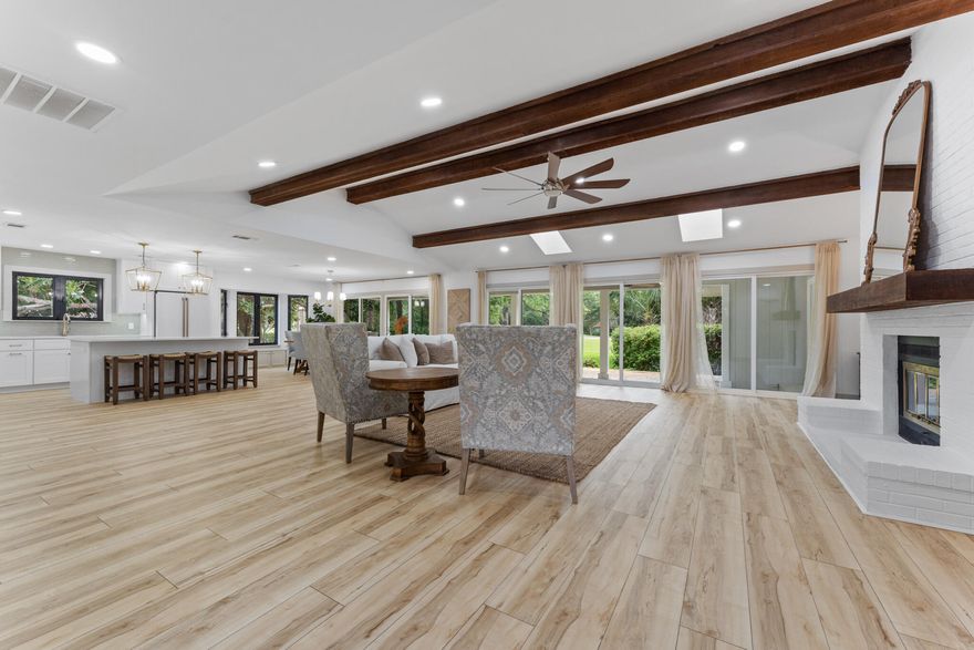 Nearly new again one level home presiding on .43 acres overlooking Links hole 5 with room for a pool, outdoor kitchen and/or screened lanai. Natural light galore from the 5 siders overlooking the green space beyond. Dramatic vaulted ceiling with stunning wood beams and mantle. Extensive list of upgrades include signature Cafe Appliances in matte white with brushed bronze handles, wine fridge in the kitchen island, quartz countertops, 2 hot water  tanks, new roof, 3 generous sized bedrooms, each with its own bathroom PLUS a powder room off the living space. OVER-SIZED (30'W X 26' L). THIS IS A MUST-SEE! Golfview is a short term rental restricted community.