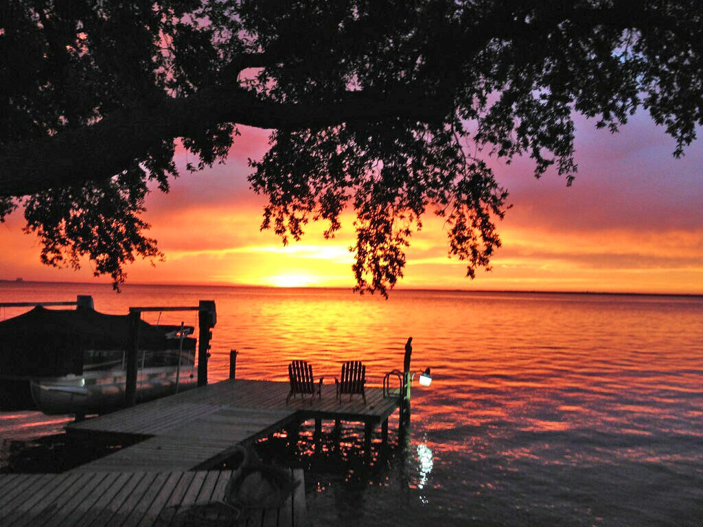 BAYFRONT living in Burnt Pine with spectacular sunset views. The secluded Bay Villas neighborhood has the convenience of the grounds being managed by the association. This 4 bedroom, 4.5 bath home is all on one floor and is immaculately maintained with a full bath for every bedroom. Spacious, open floor plan and tall windows provide the living areas with bay views overlooking your backyard entertaining area, pool and dock with boat lift. The kitchen has just been updated with granite countertops, backsplash and stainless steel appliances. The baths have just been updated as well. Gorgeous hardwood floors accent the living areas and dining room. The back patio has a ''Phantom'' retractable screen enclosure for unobstructed views. This is a must see for your bayfront buyers!