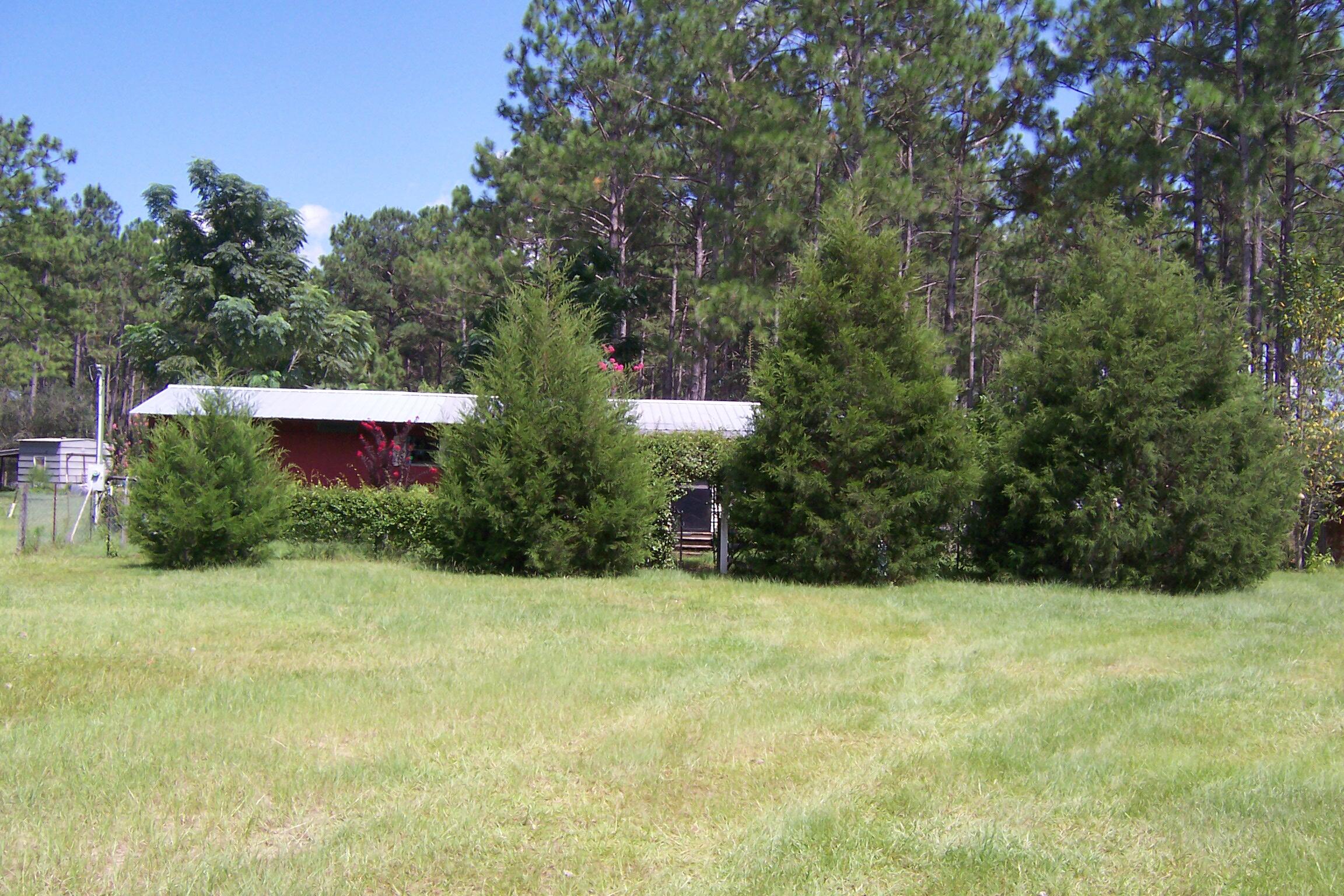 Approximately 10 acre farm in North Walton county. Property is fenced and cross fenced with nice cypress pond in rear. Has deep well, septic, and power already installed. Older 2 bedroom 1 bath mobile home located on the property currently occupied. Several other buildings and sheds. Multiple large garden areas currently growing turnips and other greens. Multiple fruit trees. Paved road frontage on Sandy Ramp and additional road frontage and driveway on Wallace Rd. Tons of potential. Property does need TLC.