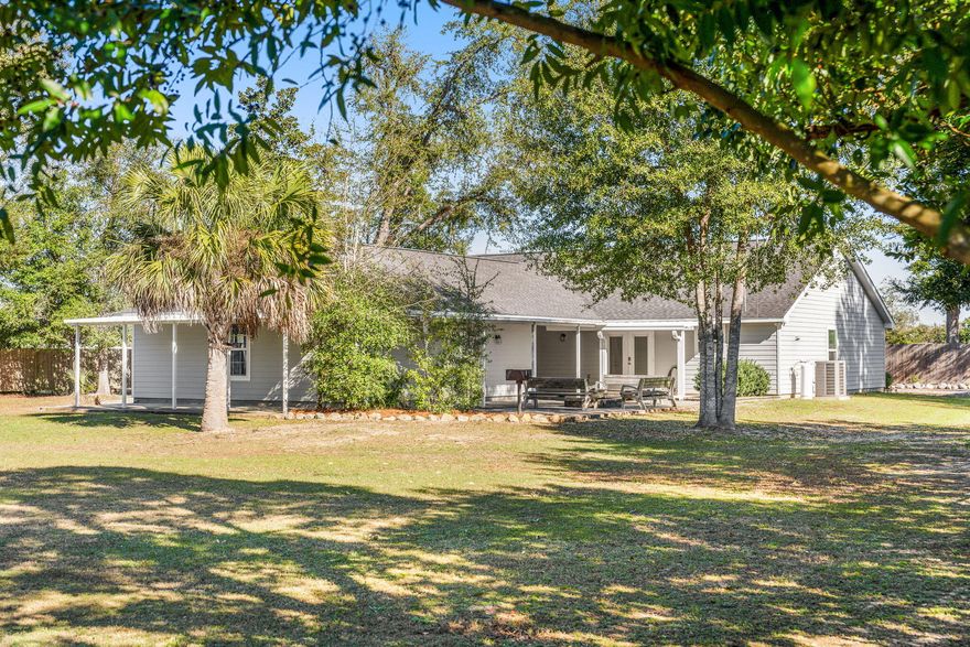 his truly one-of-a-kind property offers 3,587 square feet under roof and sits on over one acre, with the entire property fully fenced and secured by a remote/keypad-operated double gate. The grounds feature a large pole barn water and electric already run to it, along with a firewood storage rack for the outdoor firepit, creating an ideal setup for recreational vehicle storage, RV connection, or additional storage. The irrigation and sprinkler system are on a private well, supporting efficient and low-maintenance outdoor living. In addition to the 1412 sqft heated and cooled home, is a 1,062 sq ft detached two-car garage/workshop (approximately 28.4 ft wide x 26.4 ft deep) connects to the main home (1,412 sq ft heated and cooled) via a breezeway. The garage includes a designated space for a gas-powered generator (generator not installed or included) with a GE transfer switch already in place. An outdoor shower is located off the garage, and a firepit provides a natural gathering space for both entertaining and everyday enjoyment. This property is serene and perfect for nature lovers! Major system updates include an 80-gallon water heater, a 2020 HVAC system, and a 2020 roof. Inside, the home offers three well-sized bedrooms, Primary with luxury vinyl plank flooring, and all additional bedrooms with new carpet. The primary bedroom measuring 13.8 x 16.2 with a walk-in closet. The open-concept living, dining, and kitchen area provides a functional and flexible layout ready for a beautiful interior decor and design! The kitchen is thoughtfully designed and well-equipped with granite countertops, a breakfast bar, stainless GE appliances, a gas stove supplied by a 50-gallon propane tank, and both a food prep sink and a separate double sink, offering exceptional functionality for everyday living and entertaining. With ample space and room for a pool, this property combines acreage, infrastructure, and versatility in a way that is rarely available, making it well-suited for a wide range of residential and lifestyle needs.