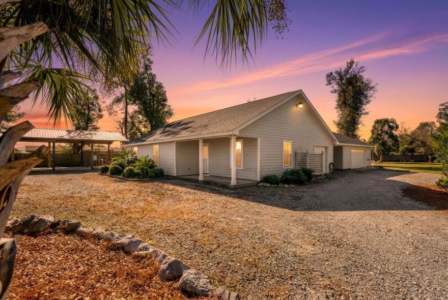 his truly one-of-a-kind property offers 3,587 square feet under roof and sits on over one acre, with the entire property fully fenced and secured by a remote/keypad-operated double gate. The grounds feature a large pole barn water and electric already run to it, along with a firewood storage rack for the outdoor firepit, creating an ideal setup for recreational vehicle storage, RV connection, or additional storage. The irrigation and sprinkler system are on a private well, supporting efficient and low-maintenance outdoor living. In addition to the 1412 sqft heated and cooled home, is a 1,062 sq ft detached two-car garage/workshop (approximately 28.4 ft wide x 26.4 ft deep) connects to the main home (1,412 sq ft heated and cooled) via a breezeway. The garage includes a designated space for a gas-powered generator (generator not installed or included) with a GE transfer switch already in place. An outdoor shower is located off the garage, and a firepit provides a natural gathering space for both entertaining and everyday enjoyment. This property is serene and perfect for nature lovers! Major system updates include an 80-gallon water heater, a 2020 HVAC system, and a 2020 roof. Inside, the home offers three well-sized bedrooms, Primary with luxury vinyl plank flooring, and all additional bedrooms with new carpet. The primary bedroom measuring 13.8 x 16.2 with a walk-in closet. The open-concept living, dining, and kitchen area provides a functional and flexible layout ready for a beautiful interior decor and design! The kitchen is thoughtfully designed and well-equipped with granite countertops, a breakfast bar, stainless GE appliances, a gas stove supplied by a 50-gallon propane tank, and both a food prep sink and a separate double sink, offering exceptional functionality for everyday living and entertaining. With ample space and room for a pool, this property combines acreage, infrastructure, and versatility in a way that is rarely available, making it well-suited for a wide range of residential and lifestyle needs.