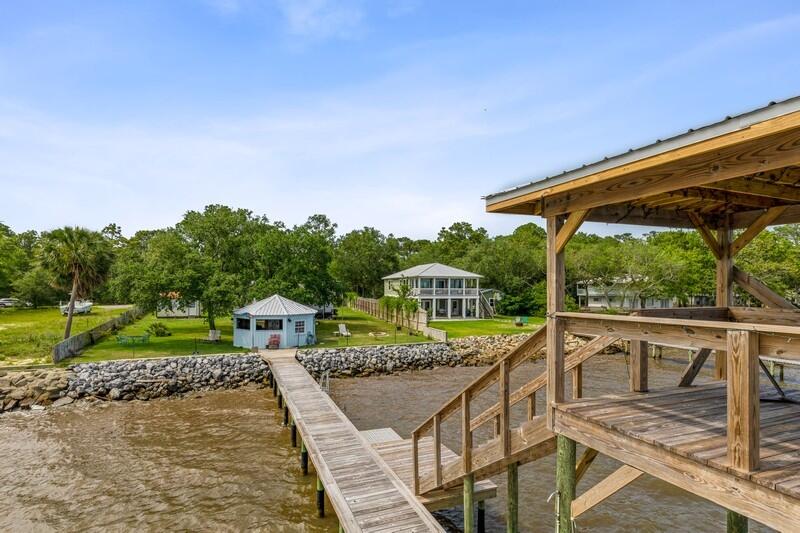 The definition of paradise should have a picture of this property in it. Open the windows and allow the wonderful bay breezes to come through.  There are so many notable features including:  public water, a greenhouse, a 12'x16'bungalow with two twin beds, washer and dryer and full size bathroom with a shower and air conditioner.  A 31' camper with 3 slide outs, sleeps 8.  A 36' tied down, metal  carport cover over the trailer that had a seal added to the roof in 2020. Propane for stove and heat.  200-250 gallon septic tank.  Plus, 18' octagonal gazebo/cookhouse fully furnished with stove, refrigerator, sink...just bring in the fish!!!.  Property has been completely sodded.  A double decker dock with a metal roof is a great place for entertaining , relaxing and enjoying an elevated view of the bay.  Hurricane strapping on every brace on both decks.  Fan is on the second deck along with an additional open area.  Hurricane tie downs have been added along with a Free Flow system along the side. Boat lift and room for ski doo.  A new sea wall was added in 2020.  Property is completely fenced in so bring the puppies.  As you see, this property has it all and  would make a great weekend getaway for you, your family and friends. 