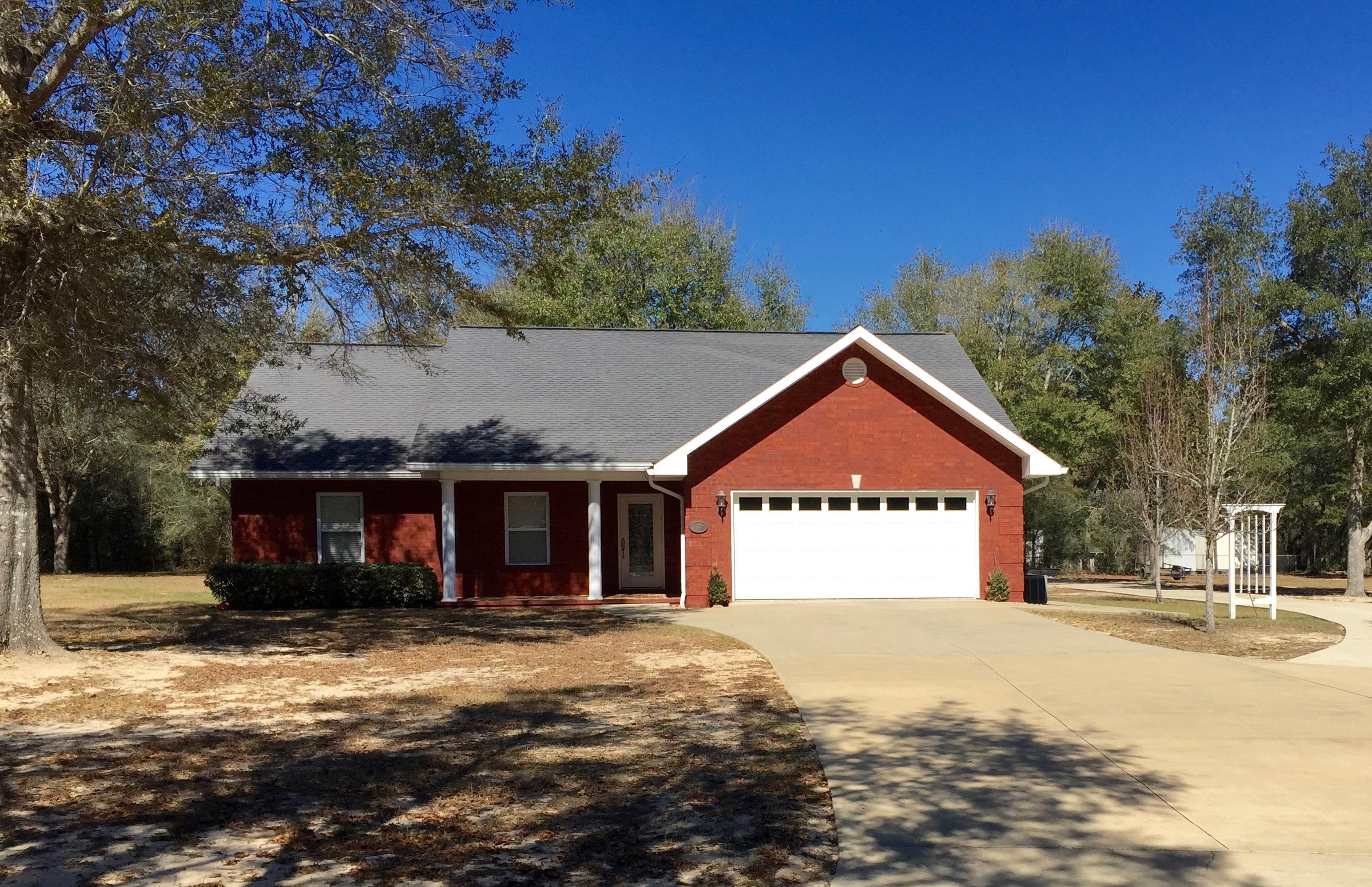 Custom Brick Home on 1 Acre within walking distance to Lake Juniper. Home features 3 bedroom 2 bath, Beautiful kitchen, Granite counters with bar, lots of kitchen space with built in china cabinet, adjoining office with built in cabinets. Master bedroom has Trey Ceilings, bath has large shower, separate jacuzzi tub, Pecan cabinets with Marble, his & hers walk in closets. Recessed lighting throughout home, Vaulted ceilings in living room, gas fireplace, Surround Sound, open foyer entrance. Front porch has travertine tile. Screened in back porch textured concrete. Detached carport with workshop, plumbed for sink & toilet, 2 car parking. This is a real beauty, home has many extras. Please see Documents for all the upgrades this home has to offer.