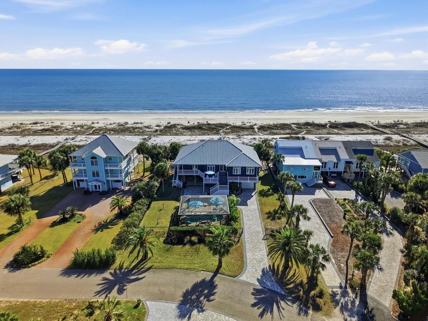 Rare Gulf Front Home-Old Florida Privacy. Welcome to 170 Gulf Pines Dr in Port St. Joe, FL, an exceptional coastal home offering relaxed Gulf living just steps from the sugar-white sands of the Gulf of America. This beautifully maintained residence features 5 bedrooms, 4 full bathrooms, and 2 half bath across 2,677 square feet of living space, making it ideal as a primary residence, second home, or vacation rental investment. The home's striking coastal exterior, durable metal roof, and elevated design are showcased in the photos and drone footage. Expansive covered porches provide inviting spaces to enjoy Gulf breezes, morning coffee, and evening sunsets, with peaceful views of the surrounding neighborhood and glimpses of the water. Inside, the spacious layout is designed for comfort and functionality, offering ample room for family and guests. The elevated construction enhances natural light and airflow, while the generous bedroom and bathroom configuration provides privacy and flexibility for entertaining. A large custom "Container Store" pantry gives one more ease of daily needs. The exceptional front-yard outdoor living area, thoughtfully designed into a private, resort-style oasis. The screened-in pool enclosure creates an open, airy atmosphere while providing shade and comfort, allowing the pool to be enjoyed year-round. Surrounding deck space offers plenty of room for lounging or entertaining. Beneath the home, a ground-level screened-in living/entertainment area provides a shaded, breezy retreat ideal for outdoor dining, relaxing, or gathering with friends and family after a day at the beach. Easy access to the pool and front yard enhances the home's seamless indoor-outdoor flow. Add'l features include a garage, ground-level storage for beach gear and water toys, and generous paved parking. Located in the desirable Gulf Pines community, this home offers easy access to downtown Port St. Joe, dining, shopping, boating, and miles of pristine Gulf beaches.