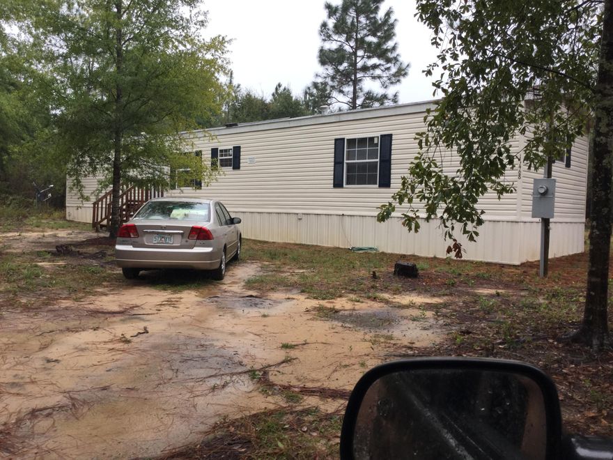 The 3+ acres of land between Milton and Crestview was purchased as undeveloped land. The septic tank and utilities were in stalled when the mobile home was purchased in 2013. The mobile home has an open and split floor plan. The Kitchen is open to the living room, has cathedral ceilings, a breakfast bar, many cabinets and plenty of counter space. The stove and dishwater are included, the refrigerator is negotiable. The large master bedroom has a cathedral ceiling and the master bath features a garden tub, separate shower, and double vanity. There are tile floors throughout which are warranted for 25 yrs. This mobile home is virtually brand new, there aren't even any nail holes in the walls.