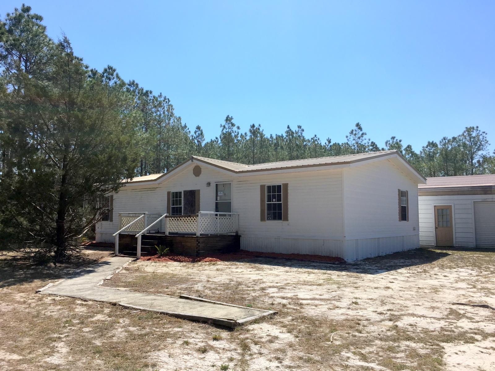 reo.Live the country life minutes from a growing town and a short distance to the beach and international airport! Boasting +/- 7.6 acres, a mobile home, and large utility building, this property is a must see! The mobile home boasts a large kitchen, laundry room with washer/dryer connection, and a split bedroom floor plan. The master suite has a ''walk-in'' closet and spacious bathroom with garden tub, separate shower, and vanity with double sinks. An oversized detached utility building sits behind the home and workbenches and three roll-up doors. Enjoy the opportunities and conveniences that come with growth but have your piece of serenity as well.