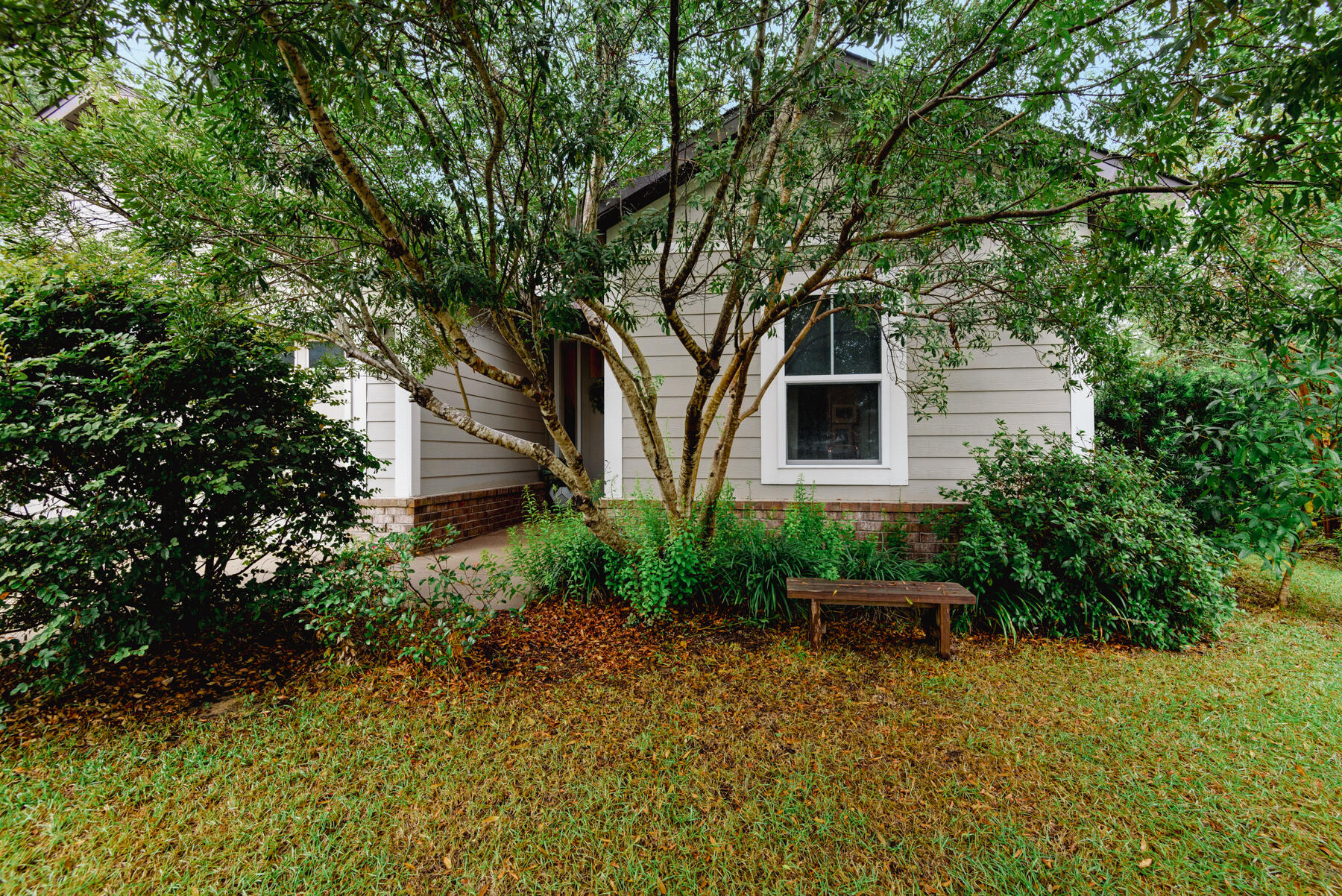 Located in a quaint wooded neighborhood on a cul de sac. Craftsman style cottage. Beautiful open floor plan. Lots of light and in immaculate condition. The back yard is a nature lovers delight. 13 Azaleas, 3 live oaks, 2 Autumn Blaze maples, productive blueberry bushes, 2 small orange trees, 1 Meyer lemon. Split bedrooms for extra privacy, porcelain tile throughout entire home. Partially fenced yard, pizza oven, and fire pit included in sale. Close to grocery shopping, parks, library and restaurants. 10' ceilings in living room and 9 ft. in bedrooms. Wood wainscoting in bathroom and reelable wall paper in hallway.Home is located yards from a private community pool and mailboxes. Peelable wallpaper in hallway.