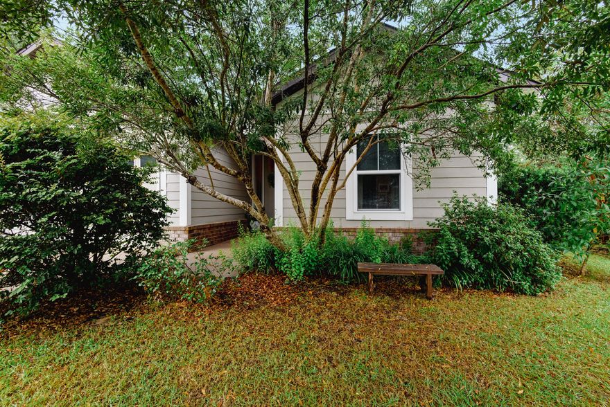 Located in a quaint wooded neighborhood  on a cul de sac. Craftsman style cottage.  Beautiful open floor plan.  Lots of light and in immaculate condition.  The back yard is a nature lovers delight. 13 Azaleas, 3 live oaks, 2 Autumn Blaze maples, productive blueberry bushes, 2 small orange trees, 1 Meyer lemon.  Split bedrooms for extra privacy, porcelain tile throughout entire home.  Partially fenced yard, pizza oven, and fire pit included in sale. Close to grocery shopping, parks, library and restaurants.  10' ceilings in living room and 9 ft. in bedrooms.  Wood wainscoting in bathroom and reelable wall paper in hallway.Home is located yards from a community pool and mailboxes.