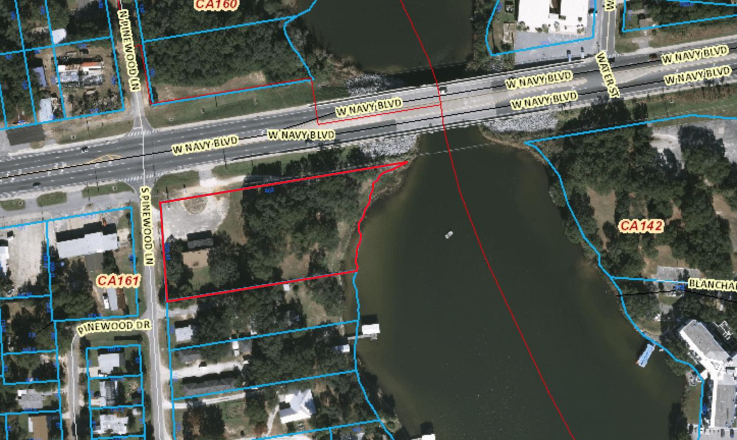 1.9 acre deep waterfront property at the corner of Navy Blvdand Pinewood lane, small structure on the property 3300 SF building