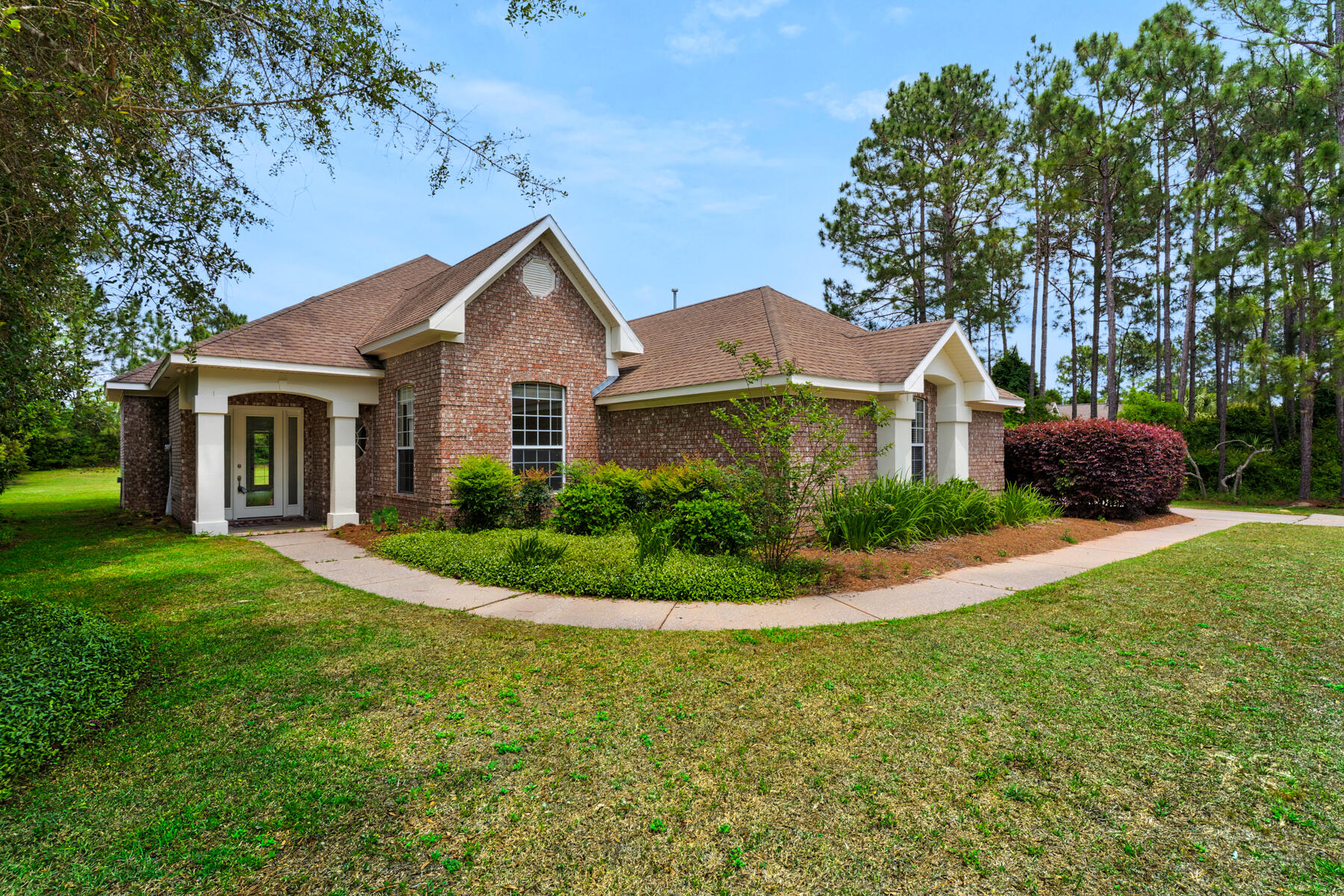This 3-bedroom, 2-bathroom home is located on the 18th hole of the Windswept Estates gated, golf course community, sitting on a private .92-acre lot. The single-story home is move-in ready with a new roof, newer AC, water heater, LVP flooring, and fresh paint. The spacious kitchen is the heart of the home, while the living room features 14-foot ceilings, a fireplace, and flows into a formal dining room, ideal for family gatherings. The primary bedroom offers a large en-suite bath and oversized walk-in closet. Both the living room and primary bedroom have direct access to a covered patio and large, private backyard perfect for outdoor entertaining.