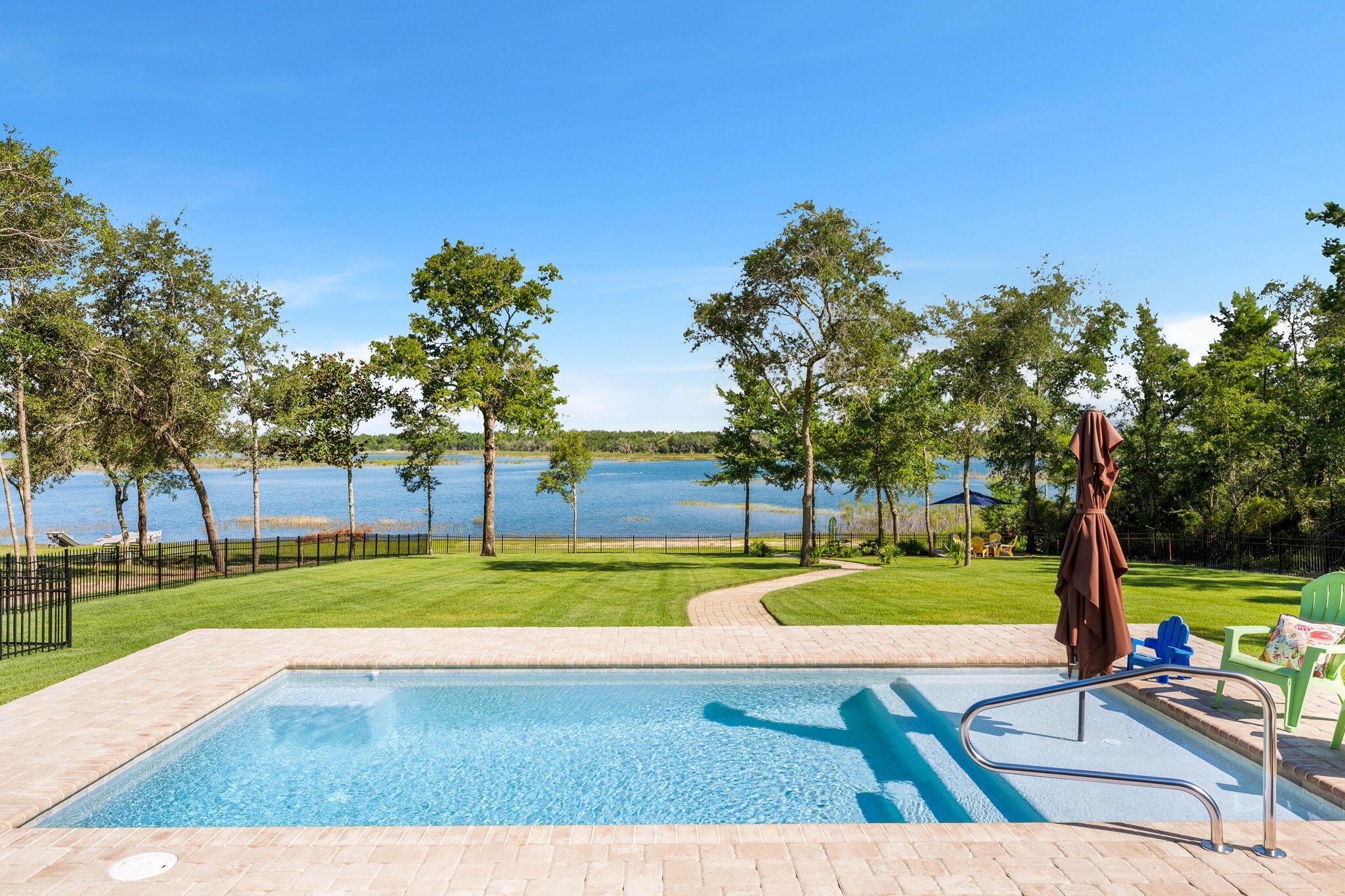 Welcome to 169 Lake Merial Blvd., a rare lakefront estate set on nearly an acre, privately positioned at the edge of the prestigious, gated Lake Merial community. With just one neighboring home and unmatched privacy, this residence offers more than 3,000 sq ft of elegant living space overlooking the sparkling, spring-fed waters of Lake Merial.Inside, you'll find timeless hardwood flooring, double tray ceilings, and a French-door entry into a handsome office with custom built-ins. The flowing layout connects a formal dining space, open living area, and a spacious kitchen with oak cabinetry, granite counters, and a custom brick-accented sitting area finished in crisp white. A newly finished heated and cooled Florida room, with its tongue-and-groove vaulted ceiling and panoramic windows, delivers uninterrupted lake views year-round.
On the main level, the home includes three bedrooms and two bathrooms, while the upstairs bonus room provides the flexibility to be a fourth bedroom, playroom, or creative retreat. The private primary suite feels like a retreat of its own with its own sitting area, featuring sweeping water views, a spa-inspired ensuite with soaking tub, double vanity, and walk-in shower, and a custom closet designed for organization and elegance.
Outdoor living reaches new heights with a brand-new 11x22 saltwater pool and sun ledge, firepit gathering area, and a paver stone walkway that leads to your private waterfront. Additional updates include fresh interior and exterior paint, redesigned black metal fencing for unobstructed views, a new 12-zone irrigation system with sod, a new well pump, updated bathrooms, and an HVAC system that is only a few years old.
Lake Merial offers 300 acres of spring-fed water for kayaking, paddleboarding, and fishing, along with community trails, green spaces, and holiday gatherings.
Set on nearly an acre with unmatched privacy, this estate delivers the perfect balance of luxury, nature, and lifestyle. From festive holiday events to food-truck nights and golf-cart cruising, Lake Merial offers a lifestyle as vibrant as it is relaxing. Schedule your private showing today and experience why this is one of the most coveted waterfront addresses in Bay County.