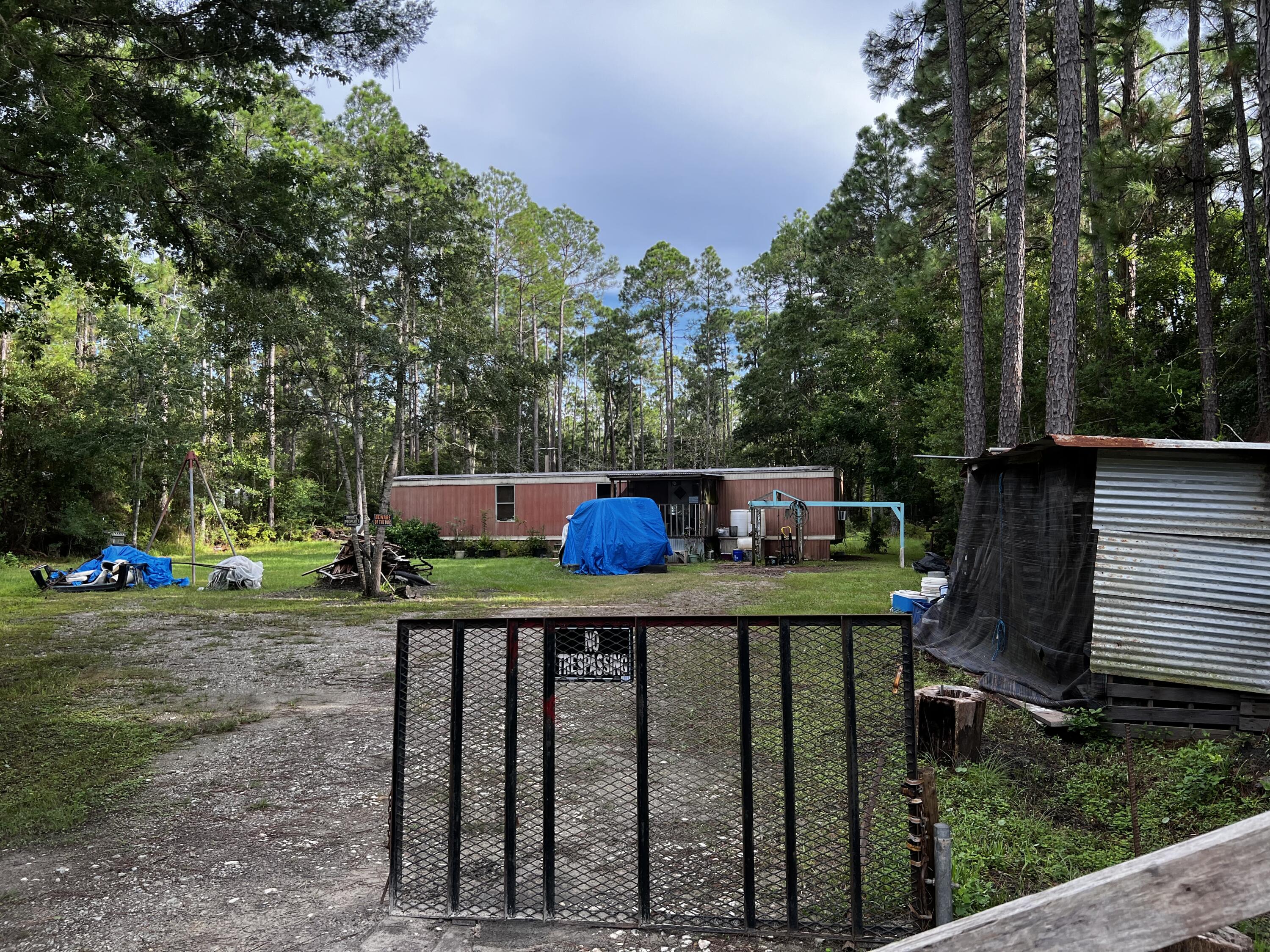 Two acres on Chat Holly Road in Santa Rosa Beach zoned Conservation Residential which allows 2 units per acre, so you could build up to 4 units on this parcel. This parcel is in Flood Zone X. It currently has 2 mobile homes on the property, but the seller doesn't have a key to either one. At least one trailer was in leasable condition not long ago, but the tenant has recently moved out. Both are vacant and will remain with the property being given no value. Probate will be complete on September 8, 2022. There are no photos of the second mobile home as I didn't quite know where it was. I know now that it is west of the driveway towards the rear of the acreage.