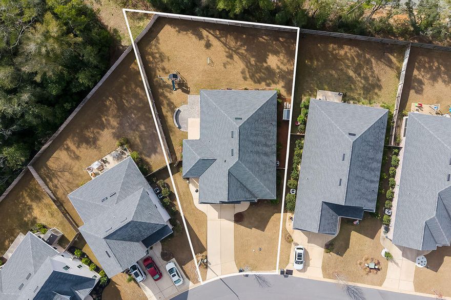 If privacy, upgrades, and maximizing space are at the top of your list, this 2021-built home delivers. Set on one of the largest lots in the neighborhood with no future homes behind it, this 4-bedroom, 2.5-bath property combines modern construction with thoughtful upgrades, flexible living spaces, and a backyard designed for both privacy and entertaining.Inside, the open-concept layout features 10-foot ceilings, 8-foot doorways, and durable luxury vinyl plank flooring throughout the main living areas. The kitchen is designed for both everyday living & entertaining, highlighted by quartz countertops, tiled backsplash, warm soft-close cabinetry with under-cabinet lighting, and Bosch stainless steel appliances with an exterior-vented range hood. The upgraded pantry includes custom shelving, electrical outlets, and additional lighting for added functionality.
The primary suite offers a spa-inspired bathroom with double vanities, quartz countertops, a frameless glass shower, and his & hers closets. All bathrooms feature tile flooring and premium finishes.

Additional interior features include ceiling fans in every bedroom, TV and ethernet drops in each room, surround sound wiring, and dedicated electrical circuits in the eaves for holiday lighting.
The flexible floor plan includes a flex space with pocket doors that can serve as an office, playroom, or additional living area. A separate bonus area with its own exterior entrance and two electrical zones offers excellent potential for a workshop, home gym, hobby space, or climate controlled additional storage.

Outside, the oversized backyard offers privacy and space to relax or entertain with a paver patio and privacy fencing. fencing. A small, screened porch provides a comfortable spot to enjoy the outdoors while staying protected from the elements. The property also includes a sprinkler system with lawn pump and well for irrigation, gutters, small storage shed, flood lights, and a welcoming front porch. Additional features for peace of mind include a termite bond, impact rated windows, and wireless ADT self-monitoring security system.

Conveniently located near military bases, schools, hospital, local amenities, and Northwest Florida State College, this home offers modern construction, thoughtful upgrades, and a highly desirable location.