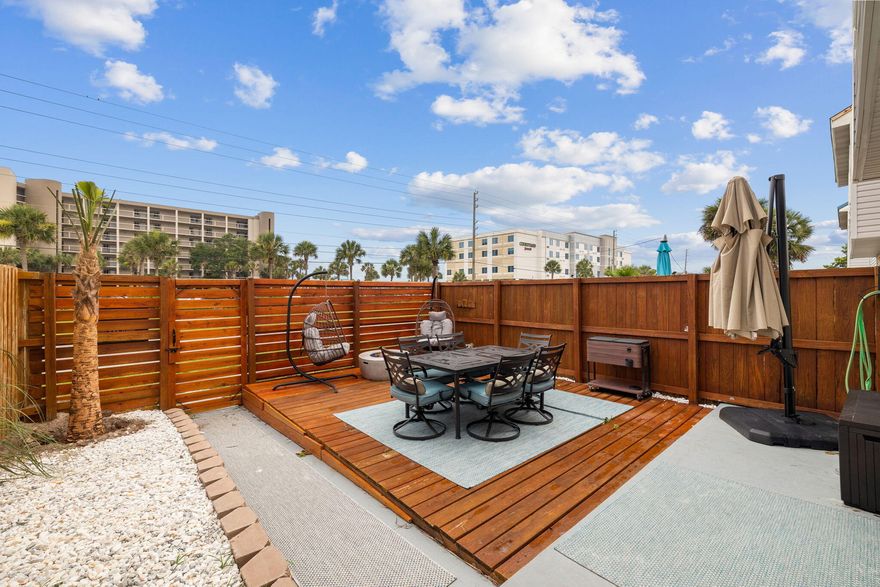 This updated townhome on Okaloosa Island offers excellent return on investment being less than 200 feet from the beach walkway and public boat dock. Beneath the new shingle roof, there's a smart porch offering a shady place to sit and watch the sun go down. Recent renovations also include a new coastal-grade AC system, a fenced patio, an all-new electrical panel, fresh paint, fixtures and sleek new bathrooms. The floor plan boasts a surprisingly light and spacious living room with shiplap walls and a cozy inset fireplace. Updated LVP flooring transitions through the dining area and into the generously sized kitchen. A full range of white cabinets and appliances provide everything you need for rustling up breakfast before heading out for the day's adventures.