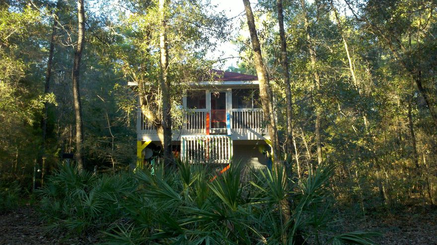 BLACK CREEK WATERFRONT! Great price on this festive Florida cottage tucked away in oaks, pines and magnolias. Perfect for a weekend get-a-way. Vaulted ceiling in Living Room with open kitchen & dining area. Screen porch on the waterside is great for enjoying the afternoon on the swing.Two bedrooms and one bath upstairs. Laundry room and half bath on ground level for easy access after fishing & boating on the River. Outdoor storage bldg/workshop with power. Must see this charming cabin to appreciate!