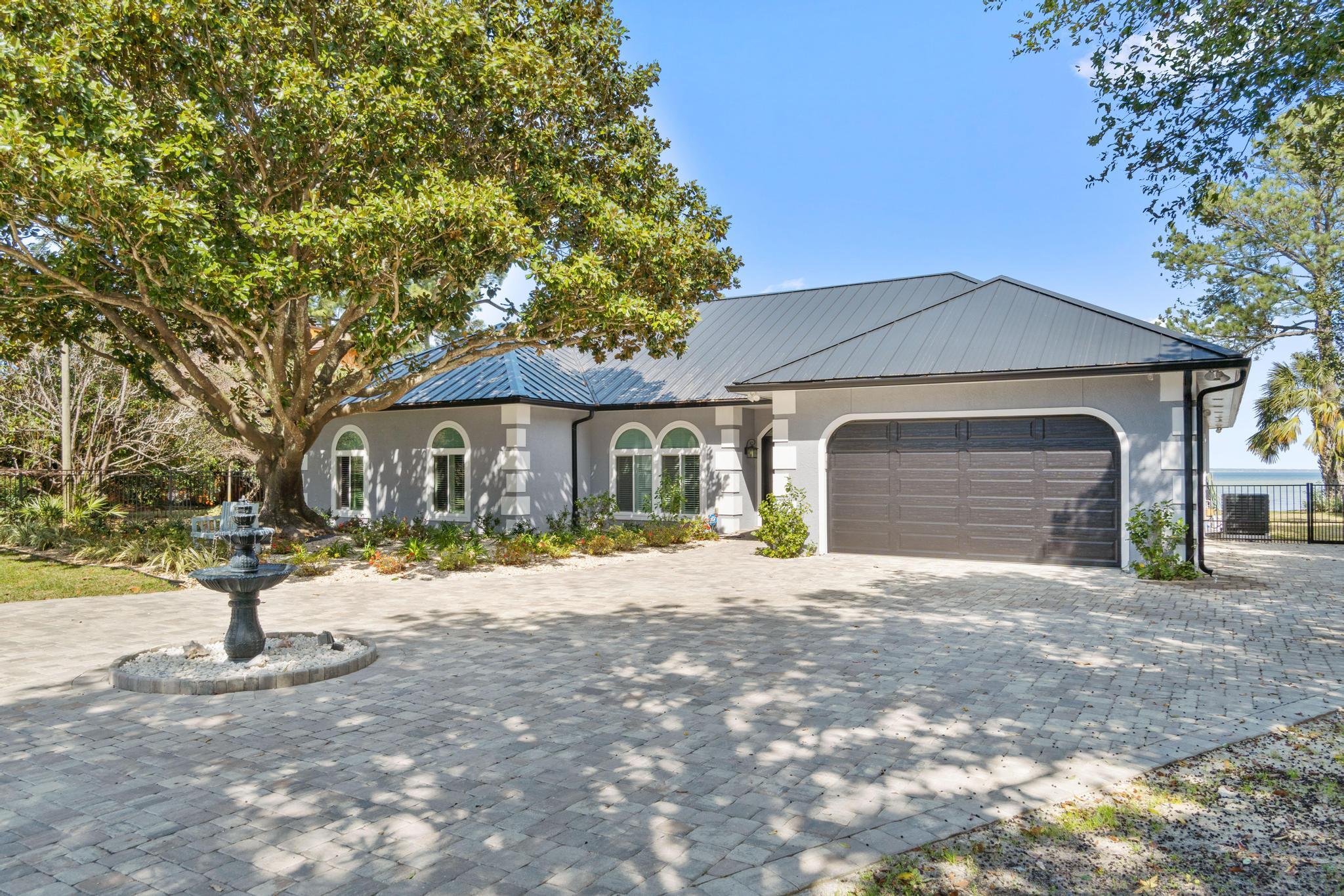 Beautifully renovated waterfront home!  A Great location in the desirable Holiday Shores Estates Subdivision, has no HOA Fees, breathtaking Bay views sitting on over 1/2 acre.  This spacious home is a 3 bed/2.5 bath with two living areas, and a separately enclosed office.  The living areas both walk out to the screened- in heated swimming pool and hot tub area.  The large Master Suite has a fireplace, gorgeous water views and also walks out to the pool area.  The home was completely remodeled in 2020 inside and out.  The interior has an updated gourmet kitchen with new appliances and tons of shelving space.  Beautiful tile throughout, updated bathrooms, extra-large pantry.  The main fireplace was re-done adding sliding barn look doors, new mantel and the list goes on... The exterior has a
