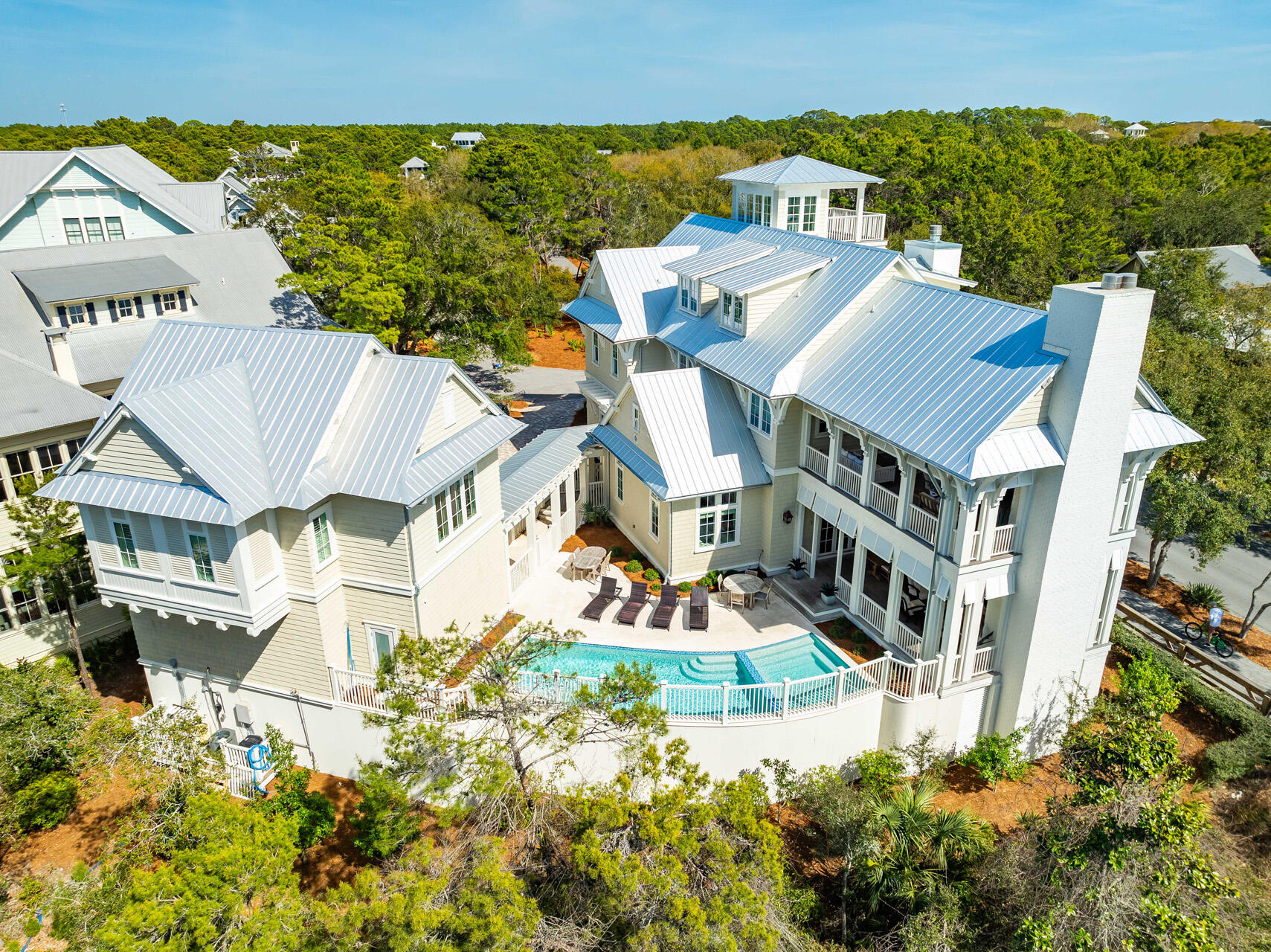 Nestled on one of the largest lots in the heart of WaterColor's sought-after Cottage District, 11 Dandelion Drive is the finest home in the community, offering six bedrooms, seven and a half bathrooms, and a private Carriage House. This stunning TS Adams-designed coastal retreat spans 6,081 square feet and blends classic architectural charm with modern luxury. Backing up to Western Lake, this home offers a serene natural setting with a trail behind the property leading to a community dock where residents can launch a paddleboard or kayak. Located just steps from Seaside and within walking distance to WaterColor's private beach club and multiple community pools, this residence provides the perfect balance of convenience and tranquility. Boasting one of the largest private pools and spas in WaterColor, as well as expansive outdoor living areas, this home is designed for relaxation and entertainment in an unmatched setting. As one of the highest rental performers in WaterColor, it generated over $418K in rental income in 2024, making it an exceptional investment opportunity. This property is offered fully furnished, ensuring a seamless transition for its next owner.
Upon entering, you are greeted by an inviting open-concept living space featuring rich hardwood floors, exposed wood beams, and an abundance of natural light. The spacious living room centers around a beautiful fireplace, creating a warm and welcoming atmosphere.
The adjacent gourmet kitchen is a chef's dream, featuring top-of-the-line appliances, custom cabinetry, a large island with ample seating, and a wet bar perfect for entertaining. A formal dining area offers space for gathering, while the breakfast bar provides a more casual dining option. The first floor also features a luxurious primary suite with an en-suite bathroom complete with a soaking tub and a walk-in shower, as well as a dedicated laundry room for added convenience.
The second level offers a cozy sitting area with a wet bar, ideal for a secondary lounge space. Three well-appointed bedrooms provide comfortable accommodations, including a primary suite with private access to a covered porch. A guest suite with a king bed and additional bunk space, as well as another king bedroom, both offer private en-suite bathrooms.
On the third floor, a spacious recreation room features a game area with multiple TVs and a ping pong table, providing the perfect setting for entertainment. A versatile guest bedroom on this level includes a king bed, a twin bed, and additional bunk space, making it ideal for larger groups or families.
A true highlight of this home is the fourth-floor lookout tower, offering breathtaking views of WaterColor and the surrounding area. This unique feature adds to the charm and character of this exceptional residence.
Outdoor living is at the forefront of this home's design, with expansive covered porches featuring gas fireplaces and plenty of seating for relaxation or entertaining. The oversized private pool and spa create a tranquil retreat, while the spacious patio allows for alfresco dining and unwinding after a day at the beach.
The separate Carriage House provides additional living space with a full kitchen, a comfortable living area, and a private guest suite, making it an excellent option for visitors or extended family stays.
Situated in one of the most desirable locations along 30A, this remarkable home offers access to WaterColor's world-class amenities, including tennis courts, pickleball courts, nature trails, lush parks, and a private beach area. With its prime location near Seaside, charming boutiques, and fine dining, 11 Dandelion Drive presents a rare opportunity to own a luxurious coastal residence in one of the most prestigious communities on Florida's Emerald Coast. Contact us today to schedule a private viewing of this extraordinary home.