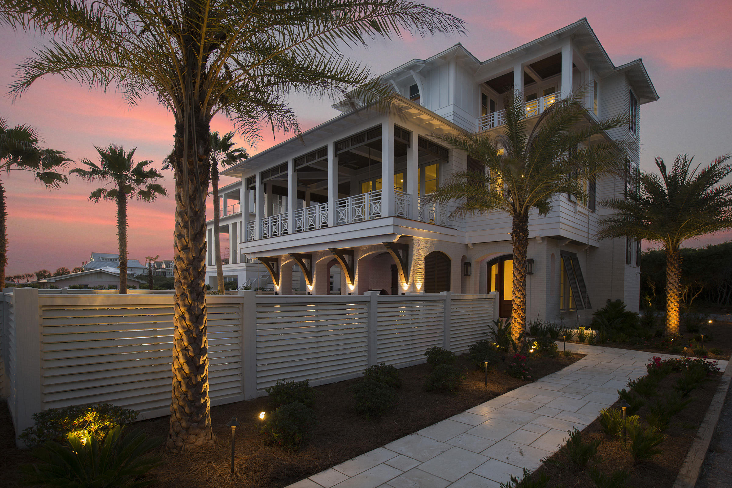 This custom coastal estate home is a mastery of architecture and innovative design fashioned with clarity and intention. It is progressive and classic at the same time, encompassing the essence of luxury living. The design team of architects, interior designers and landscape professionals created this distinctive home with the vision of developing a four-home enclave in the heart of Inlet Beach. This home, and the one next door, comprise two of the four. The lots behind are available for the completion of this exclusive mini-neighborhood. One row back from the beach, 292 Pompano maximizes its prestigious location through its exterior and interior designs. Beautiful stone walkways lead past a white privacy fence to a handsome arched mahogany door and mosaic-tiled water feature. The