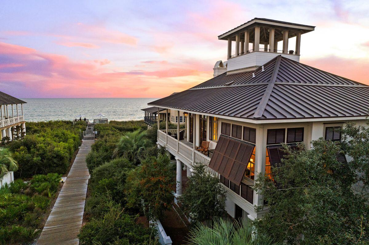 This elegant Rosemary Beach home enjoys panoramic 180-degree views of the gulf enhanced by elevated wrap-around porches, a prominent cupola, and second floor living. The home is ideally positioned one back from the gulf, steps from the sandy beach, on a large lot with 60-foot view corridors. Enter the home through the brick-paved courtyard, passing the private heated pool and lounging area before entering a magnificent foyer with marble flooring. The home's garden level first floor has three en suite bedrooms (two junior suites), bunk room and laundry room. The three garden level bedrooms have porch access for enjoying early morning coffee in the privacy of your own space surrounded by lush vegetation.