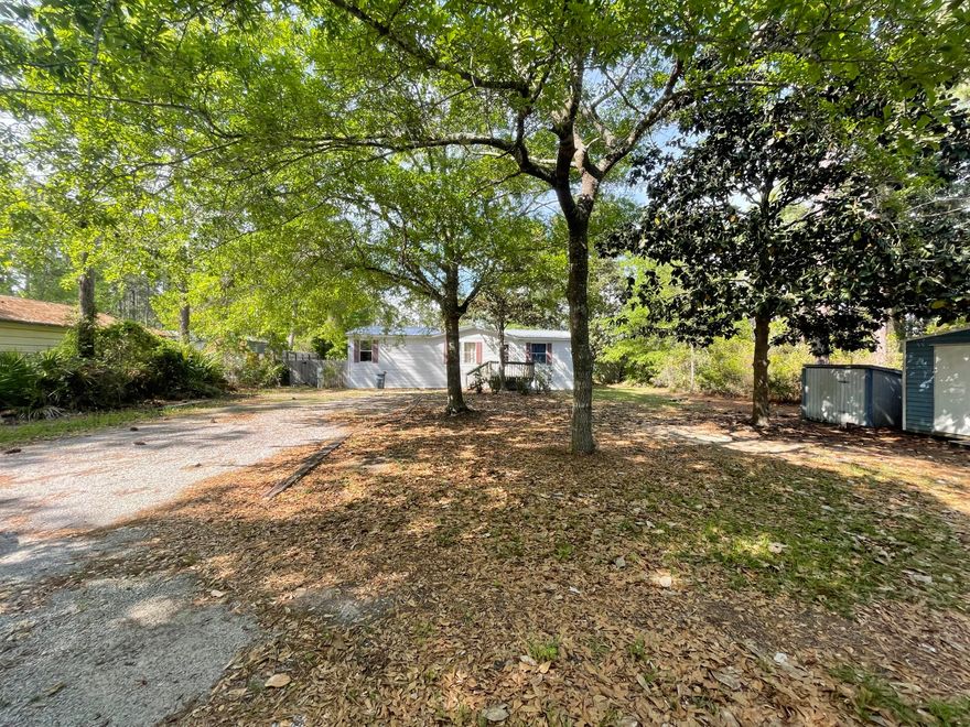 Location location location!!  The perfect starter home for a young family, an affordable paradise, w/ mature Magnolias, oaks and other flora, an 8x12 shed/workshop in perfect condition. This double-wide manufactured home on a large lot with fenced in back yard.  stainless steel appliances, hardwood floors and beautiful metal roof, this one must see.