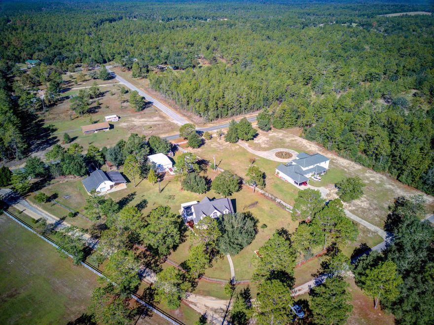 Southern Living on your 2 Acre Lot with TONS of extras! Workshop, covered parking for all your recreational toys, deep well and irrigation, fully fenced level lot, bearing fruit and nut trees, RV hookup, porches, game room, man cave with 1/2 bath, CUSTOM Home and Gourmet Kitchen! Gorgeous entry with a covered porch welcomes your guests. Step into the Foyer with hardwood floors and elevated ceilings. Living Room w/cathedral ceiling opens up to the Kitchen and Den. DREAM Kitchen w/double ovens, dual fridges, commercial 6-burner range and hood, custom cabinetry, granite counters, and kitchen island w/breakfast bar seats 5! Dining Room is located off the Kitchen and accented with a tray ceiling and bay window. Private Master Suite features french doors to covered porch and a luxury bathroom. Luxury Master Bathroom features a jetted soaker tub, separate walk-in-shower, linen cabinet, and appliance garage for your coffee/tea maker! Master bedroom has an 8x6 walk-in-closet.  The additional 4th bedroom on the main level is at the front of the house and currently being used as an office. Powder Room is conveniently located off the living room. Bedrooms 2 and 3 are located on the 2nd floor and share the 2nd Full Bathroom.  Walk-in attic storage can be accessed from Bedrooms 2 and 3, and each bedroom features dual closets. Utility Room next to the Kitchen has plenty of storage with custom cabinetry and a laundry sink.  From the Utility Room access your heated and cooled Florida Room with an attached covered parking area perfect for unloading the groceries. Enjoy all the amenities on your land with a 40x20 Garage featuring two garage doors, and one door functions as your security gate from your driveway off of Mount Olive Road. Plenty of space in the Garage for your work benches and tools and still be able to use the garage as a pull through. Reinforced concrete can handle heavy machinery! 3 bay carport on each side of the Garage is perfect for parking all your recreational toys or yard toys. Plus, a 38'7x14'10 separate living area or game room above the garage is cooled with a window a/c unit and heated with a space heater. Additional Workshop on the North side of property has a 3 Bay Carport, Storage/Man Cave with ???? Bath and RV hookup. Full RV hookup is available on property with water, electric, and septic tank. So much more to this home! Take a look at the feature sheet and be sure to schedule your private viewing!