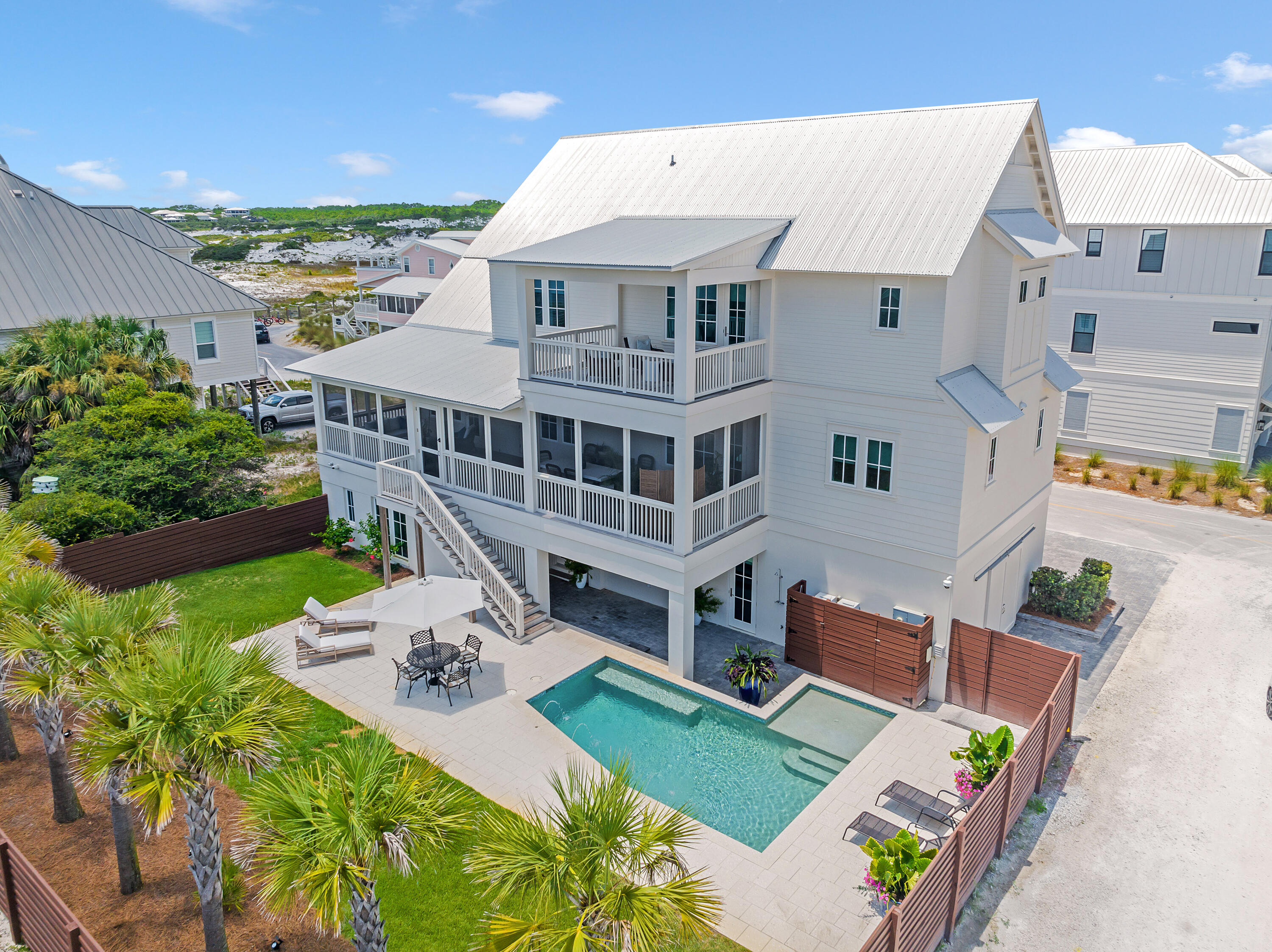 Prominent Grayton Beach five bedroom, five bath  and two half baths is just steps away from one of the most renowned beaches and beach walkover in Florida. It's remarkably designed and customized on a corner lot, spacious yard, private pool, guest quarters, and its eye-catching gulf views. This guest apartment suite on the ground level is accessed by a private entrance and has additional parking. The second floor features a spacious living area with beautiful exposed wood beams, custom barn doors, and saw-cut hardwood flooring, reflecting the natural environment. Three contemporary pendant lights are the focal point over the open boastful chef's kitchen that comes fully equipped with a 48-in. six-burner Wolf gas stove, cool marble countertops and a floor-to-ceiling wine refrigerator.