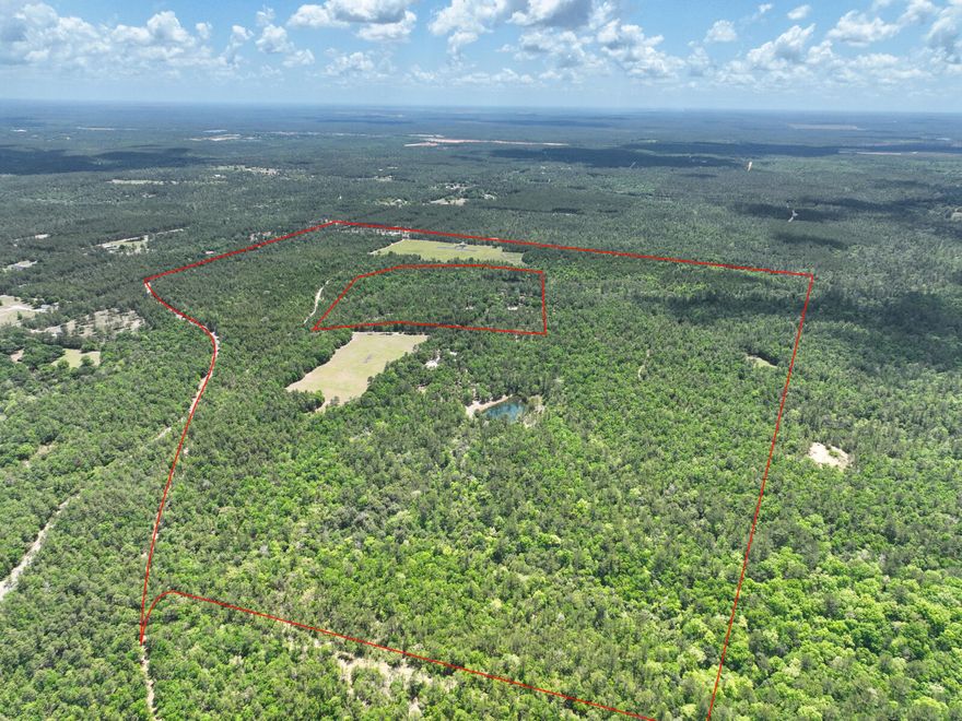 Do not miss out on this opportunity!!! This is 200-300 acres of possibilities with a WATERFALL in Florida!? If you're looking for hunting land, an outdoor retreat, access to your own creeks and ponds, and true privacy, this is it! The main house has four bedrooms, three full baths, an office, plus a massive bonus room upstairs, and it was built to last! It has a steel frame, brick & hardie board exterior, a metal roof, and solid core insulation.  You can rest assured that you will be comfortable in this home with beautiful views of the pond in the backyard.  Other features of note for the home are the large 4'' well, 2x250G propane tanks, and a whole home Generac Generator for backup power.  There is also a fantastic garage/workshop with plenty of storage as well as covered parking (with... electrical hookup) for a full sized Class-A RV!  The pond in the backyard has a lovely gazebo and is stocked with bass and bream for some relaxing fishing.  As you explore the acreage, you'll see plenty of wild berries, such as blueberries and huckleberries.  If hunting is your passion, you won't find a shortage of wildlife on this land with deer, turkey, squirrel, and boar throughout.  There are also some food plots established, and three deer stands are set up to enjoy.  To hone your skills, there's also gun ranges established on the land (pistol, 100m, and 200m are set up). The owners will sell the north 200 acres of the existing parcel for the primary sale, but the additional 100 acres adjoining to the south could be purchased if desired for an additional $500,000. The southern 100 acres offer 6 RV Hookups with power and water (no septic), a 50' x 300' flying field for large scale RC Planes, beautiful cleared area and flat land, and a pavilion built for the flying field. There are endless possibilities with so much room for activities!
