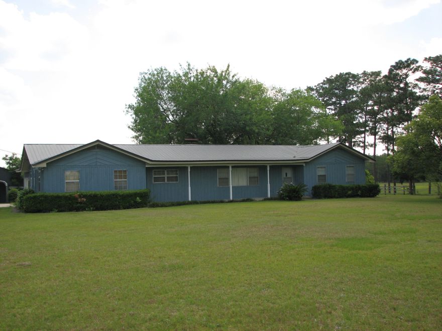 COUNTRY ROAD TAKE ME HOME to this well maintained 2200+ SF home on approximately 42 acres (owners are in the process of getting a survey). Straddle the fence on the northern boundary and you have 1 foot in Alabama and Florida at the same time!! Cleared pasture area + wooded area + fencing to keep in horses, cows or kiddos. Large mature trees provide plenty of shade when sitting on the patio in the evening, open floor plan from the kitchen to the dining/family room w/wood burning fireplace, bedrooms are all very large, inside laundry area has room for freezer. Roof was replaced approx 8 years ago. Two 18x20 covered structures for boats, RVs, farm equipment or extra vehicles plus main home has garage. Impressive barn/workshop is oversize with multiple roll up drive thru access doors !